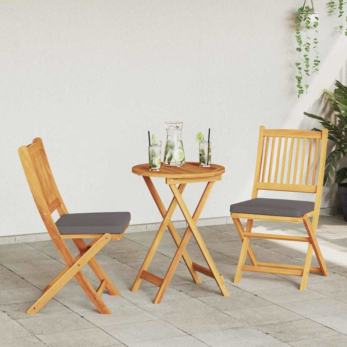 Szene im Freien mit einem Holztisch und zwei Stühlen. Getränke stehen auf dem Tisch. Pflanzen sind im Hintergrund.