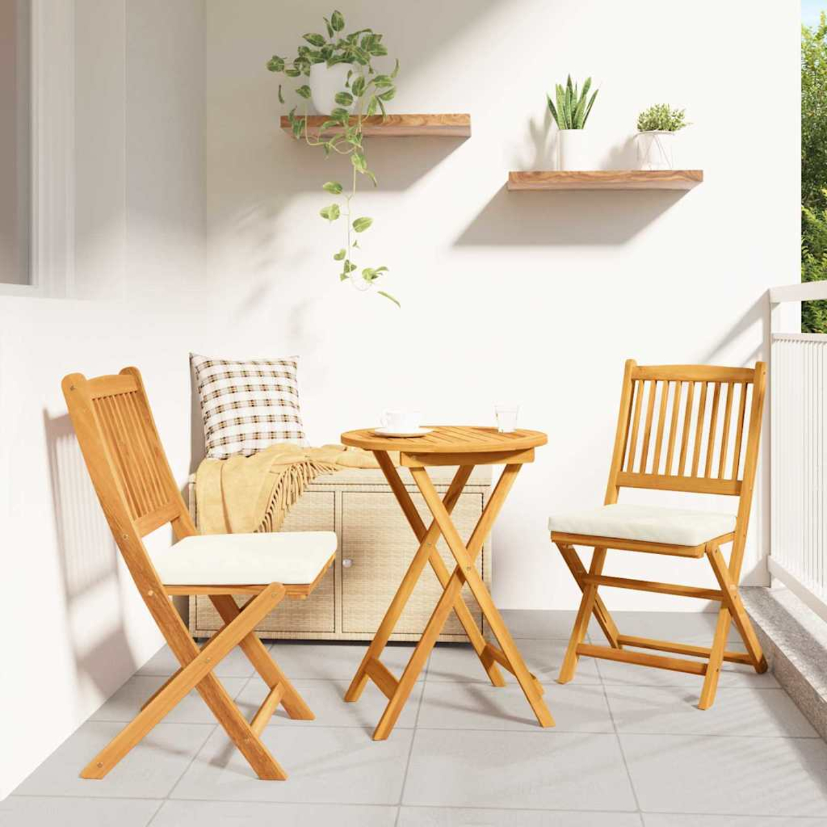 Ein Balkon mit Holztisch und Stühlen, einem Schrank und Pflanzen auf Regalen. Ein Kissen und eine Decke liegen auf dem Schrank.