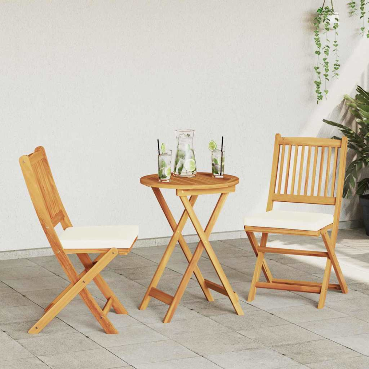 Holz-Terrassenset mit Tisch, zwei Stühlen und Getränken. Getränke enthalten Wasser, Limette und Minze. Pflanzen sind im Hintergrund sichtbar.