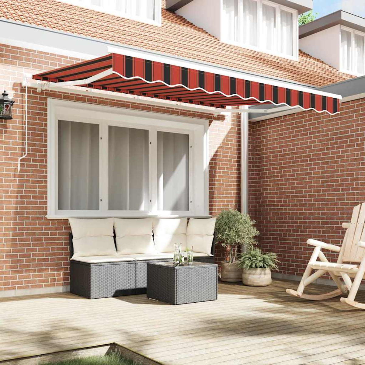 Eine Terrasse mit einer rot-schwarz gestreiften Markise. Es gibt eine Couch, einen Tisch, Pflanzen und einen Schaukelstuhl. Ziegelmauer und Holzterrasse.