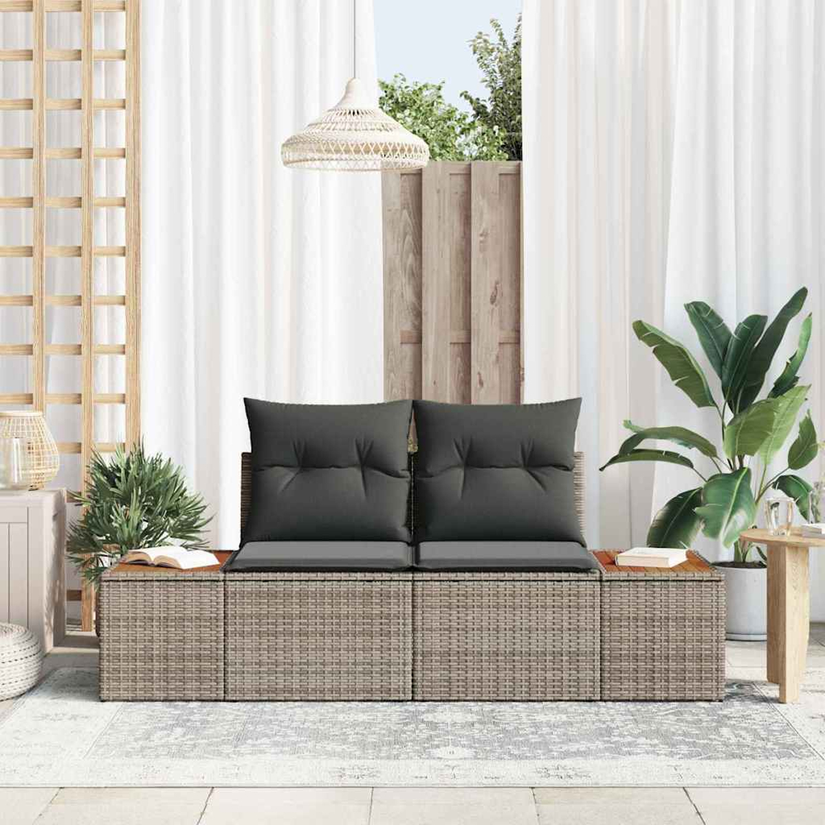 Außenszene mit einem geflochtenen Sofa mit grauen Kissen. Weiße Vorhänge, Pflanzen und ein hölzernes Gitter im Hintergrund.