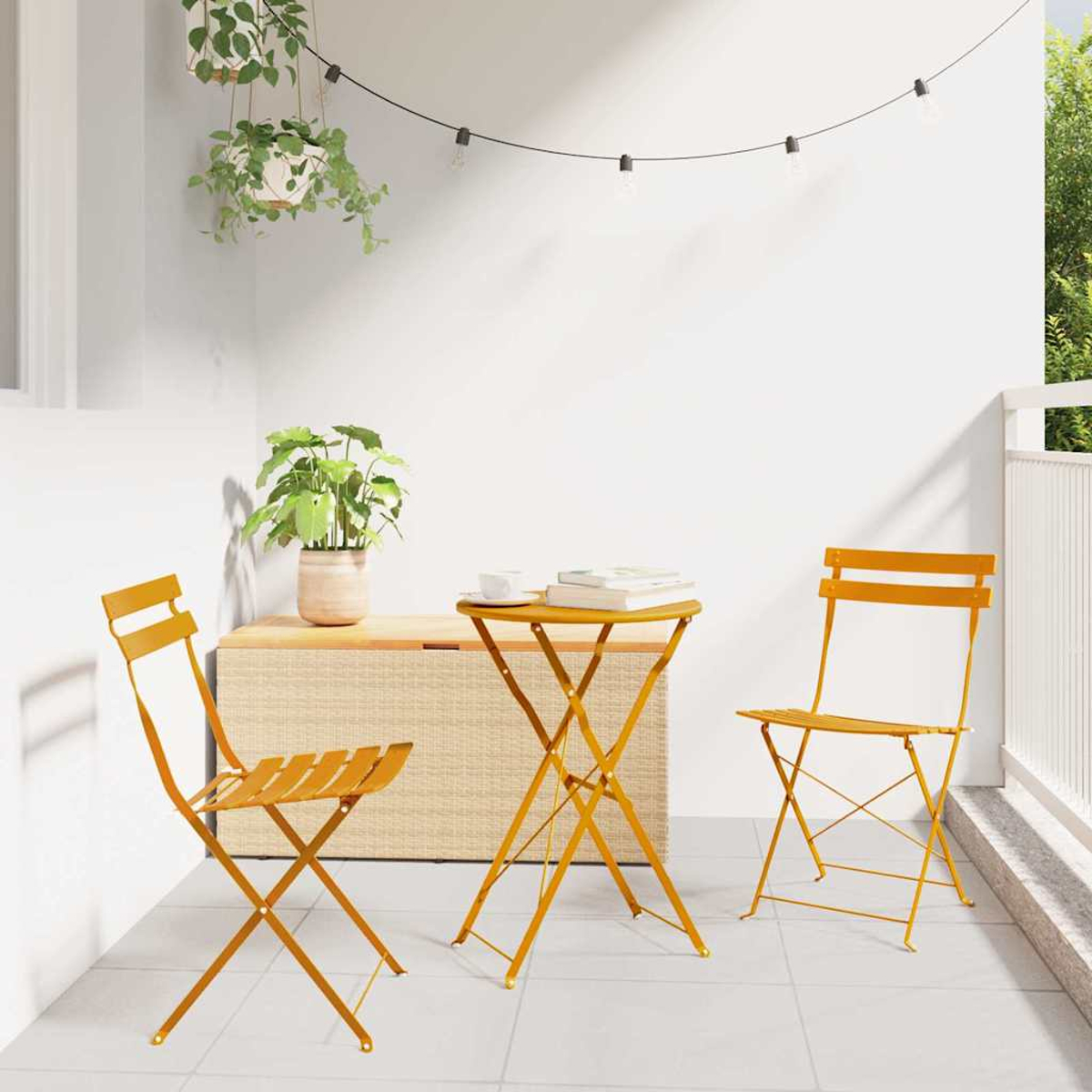 Ein gelbes Bistro-Set auf einer Terrasse. Enthält einen Tisch, zwei Stühle, eine Holzkiste und Pflanzen. Lichterketten hängen darüber.