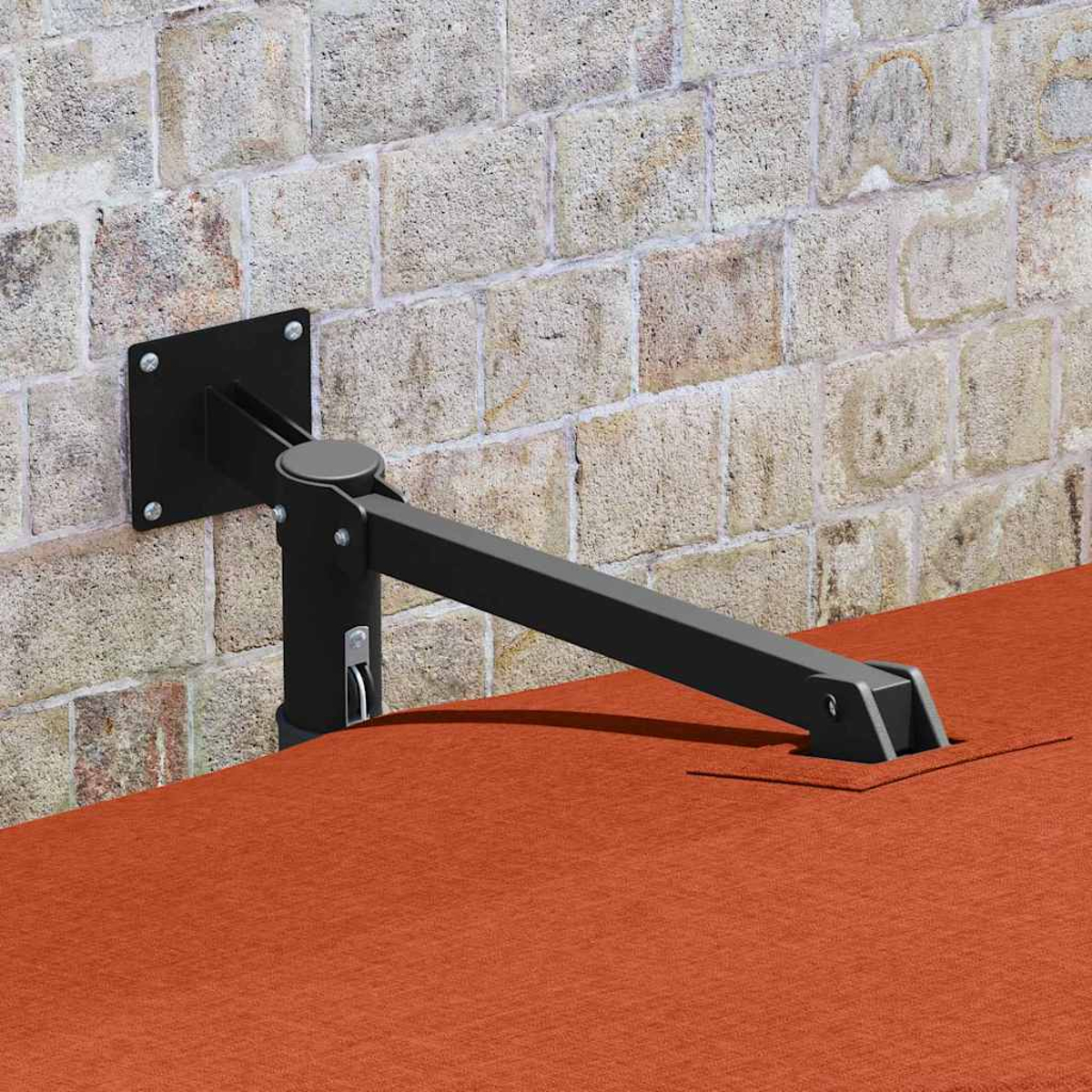 Ein schwarzer Metallstützarm ist an einer Ziegelmauer befestigt. Darunter befindet sich eine orangefarbene Oberfläche. Der Arm stützt etwas.