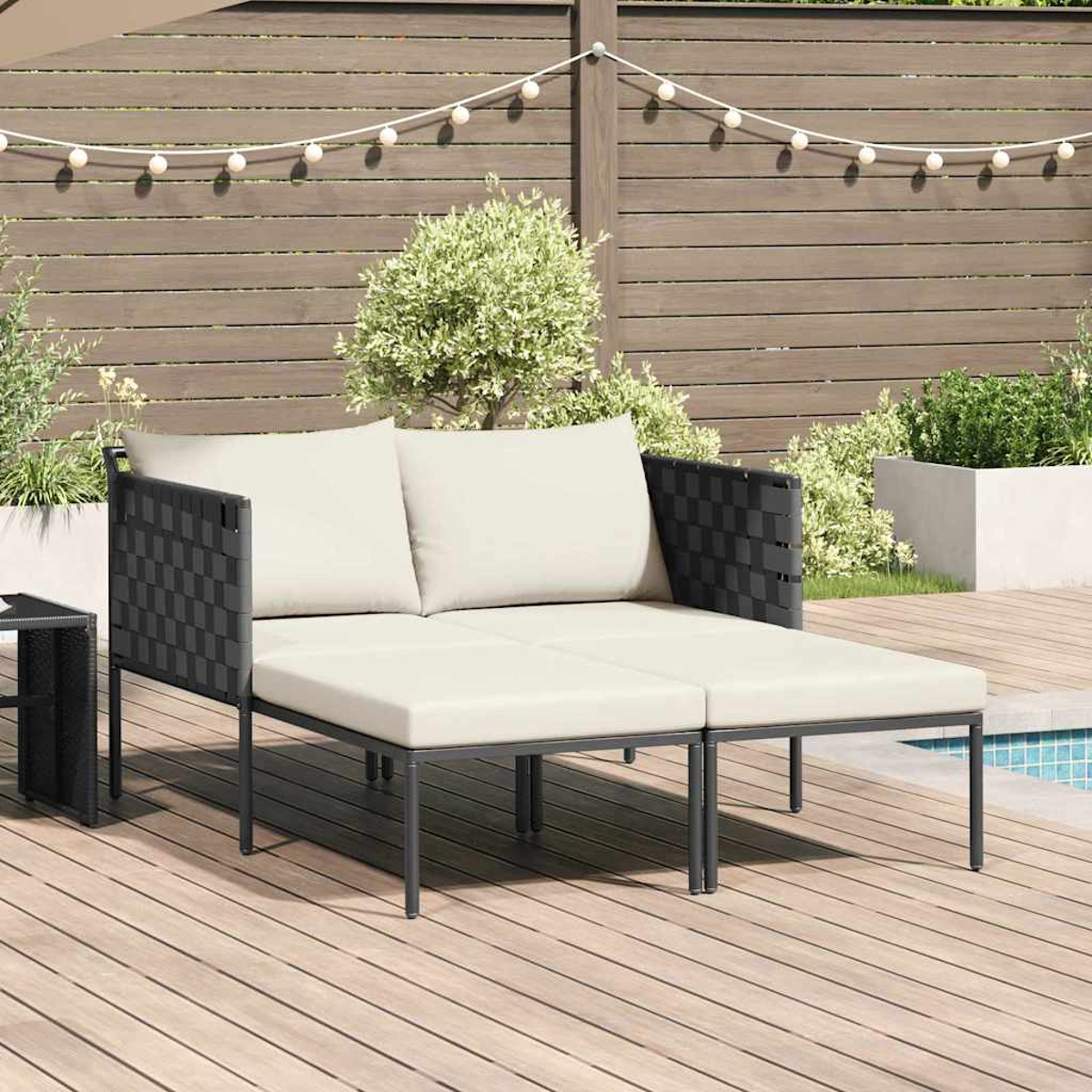 Outdoor-Ecksofa mit cremefarbenen Kissen und schwarzen, gewebten Seiten. Holzboden, Garten, Zaun und Lichterkette im Hintergrund.
