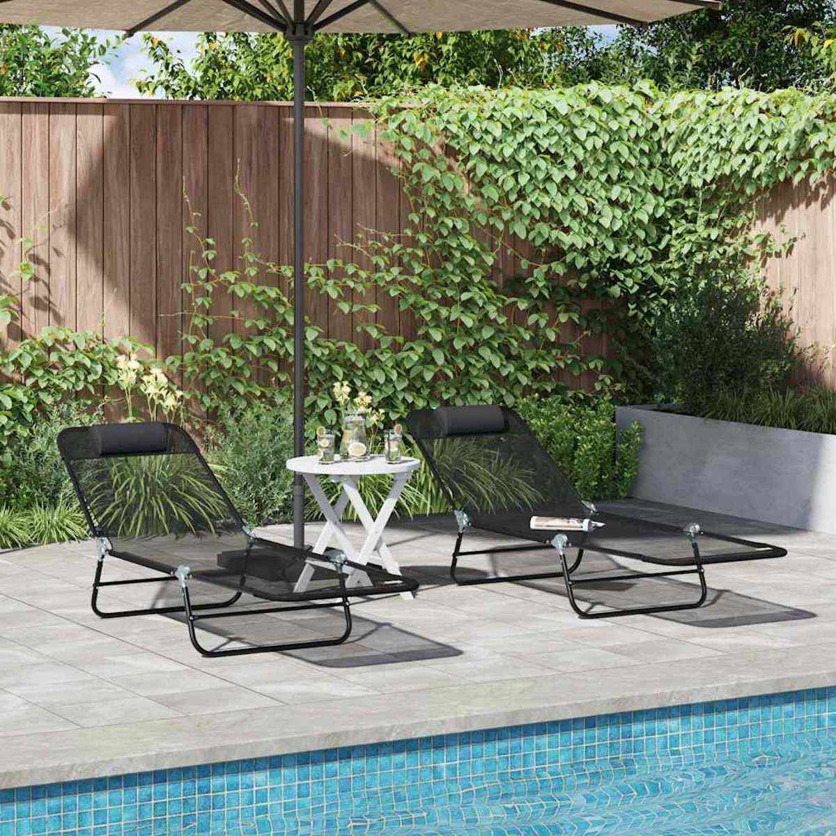 Zwei schwarze Liegestühle am Pool unter einem Sonnenschirm. Ein kleiner weißer Tisch hat Getränke. Ein Holzzaun und Pflanzen sind im Hintergrund.