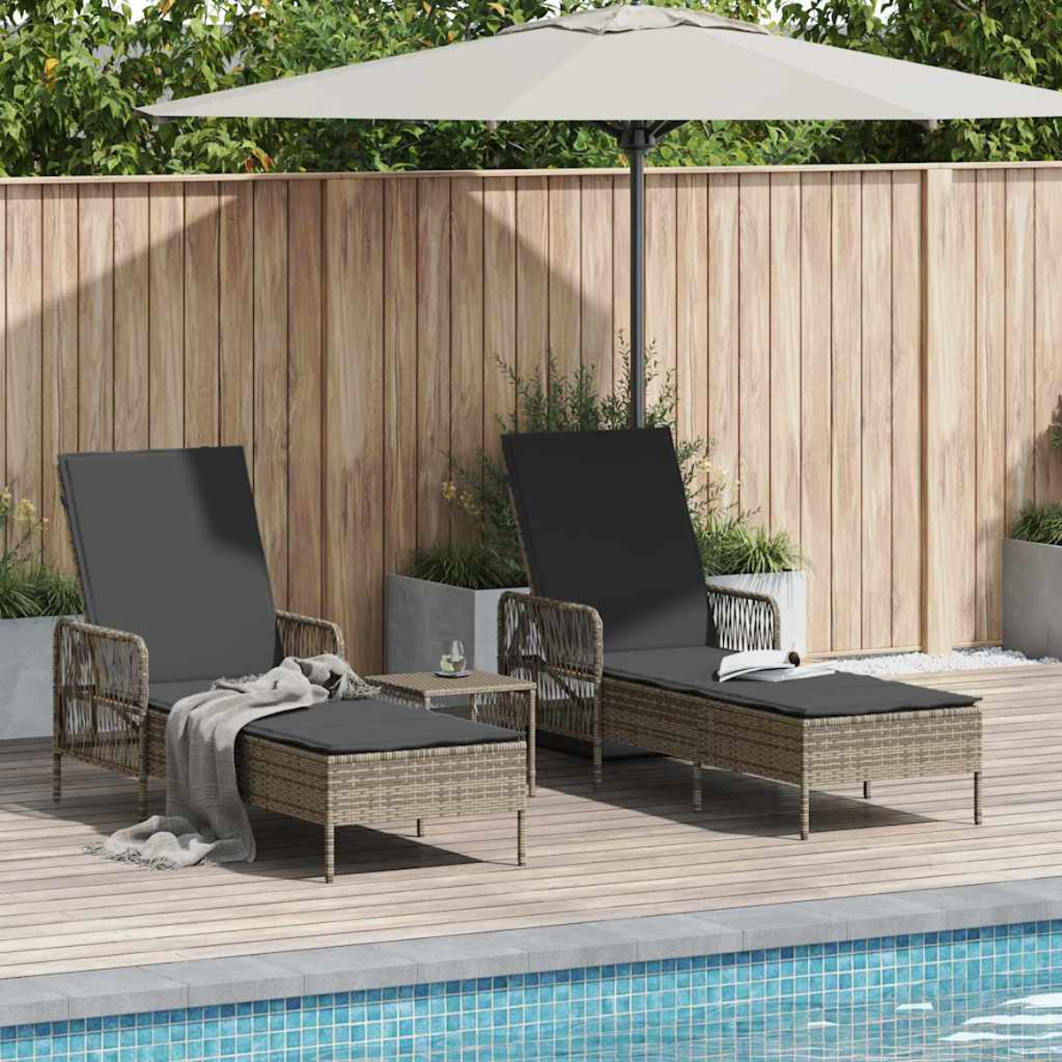 Zwei Liegestühle mit schwarzen Kissen und ein kleiner Tisch unter einem beigen Sonnenschirm am Pool. Im Hintergrund ein Holzzaun.