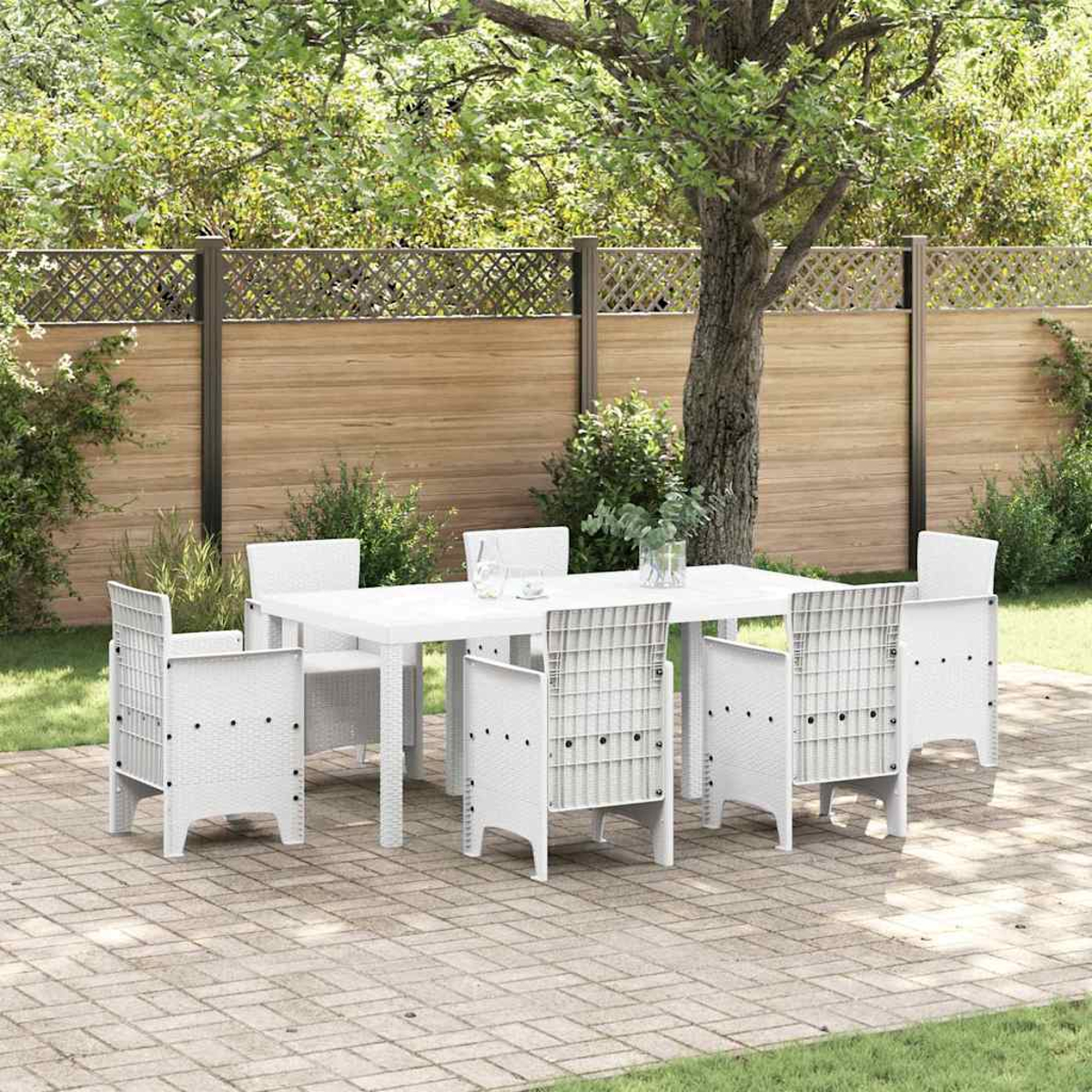 Ein weißes Ess-Set im Freien auf einer Terrasse. Es umfasst einen Tisch und sechs Stühle. Ein Holzzaun und Grünzeug sind im Hintergrund.
