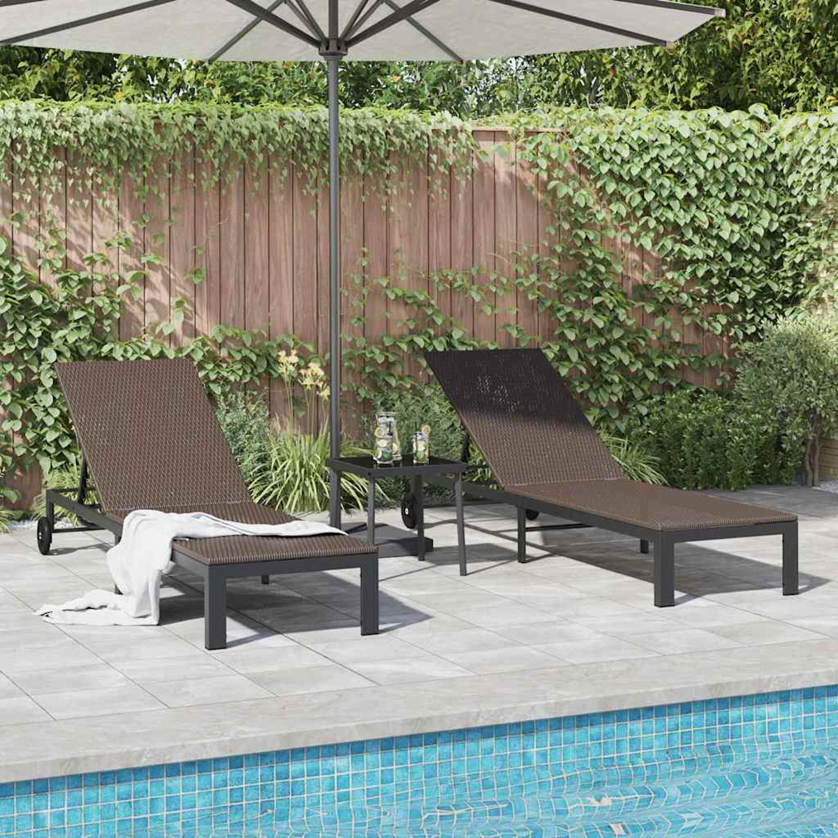 Zwei braune Korbliegen mit einem kleinen Tisch, Sonnenschirm und Pool im Vordergrund. Ein Holzzaun und Grün im Hintergrund.