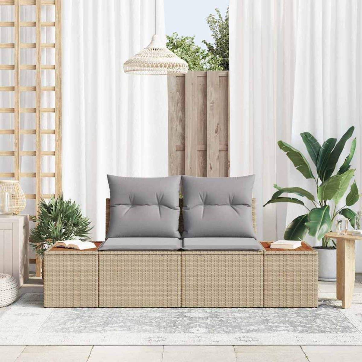 Outdoor-Sitzgelegenheit mit grauen Kissen, umgeben von Pflanzen und weißen Vorhängen. Ein Holzgitter und eine gewebte Lampe sind ebenfalls sichtbar.