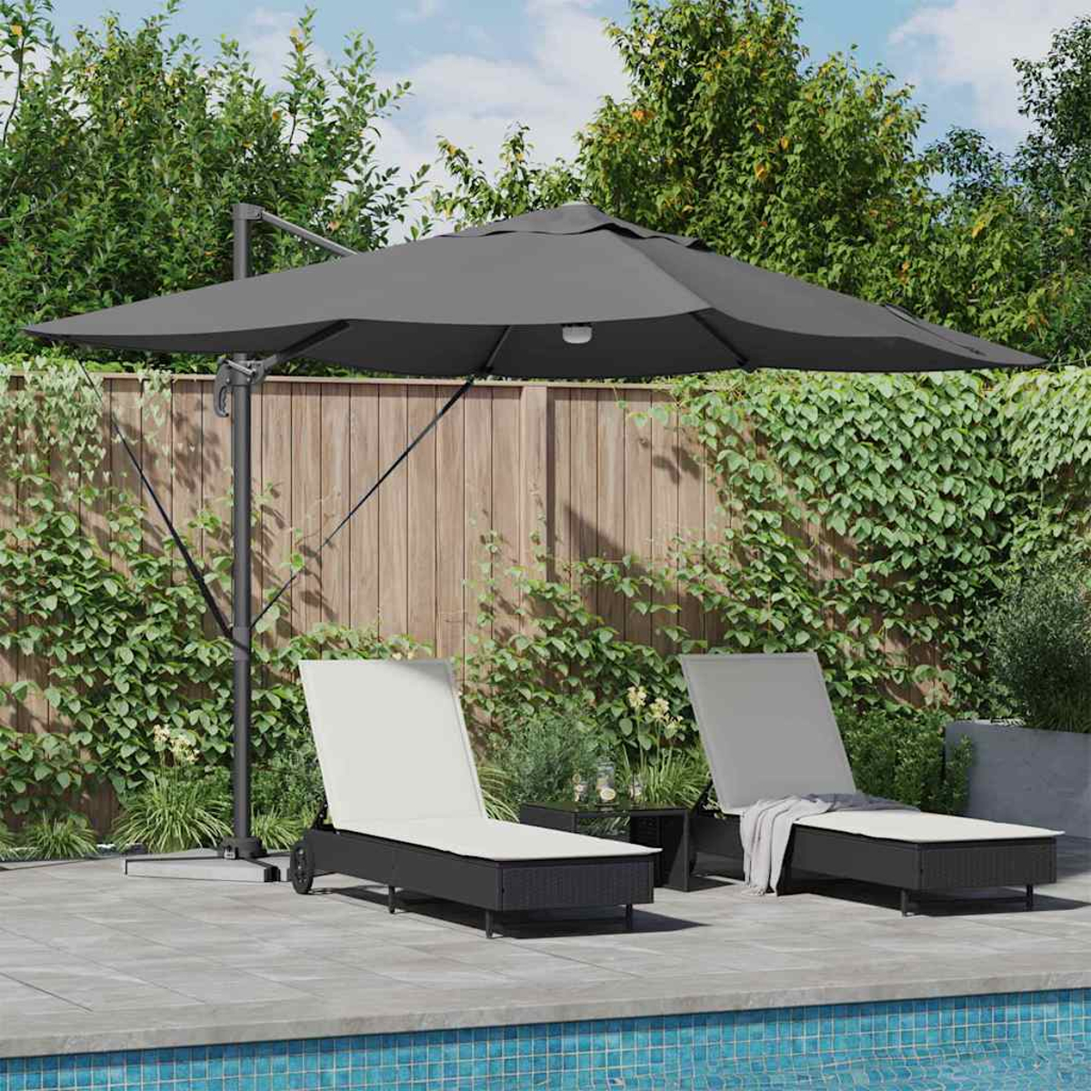 Zwei Liegestühle unter einem großen grauen Sonnenschirm am Pool. Ein kleiner Tisch steht zwischen den Stühlen. Grüne Pflanzen und ein Holzzaun sind im Hintergrund.