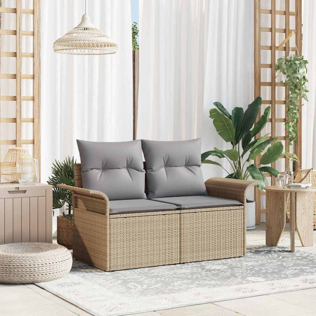 Ein Rattansofa mit grauen Kissen steht auf einem Teppich. Pflanzen und ein Beistelltisch sind in der Nähe. Überkopf hängt eine gewebte Lampe.