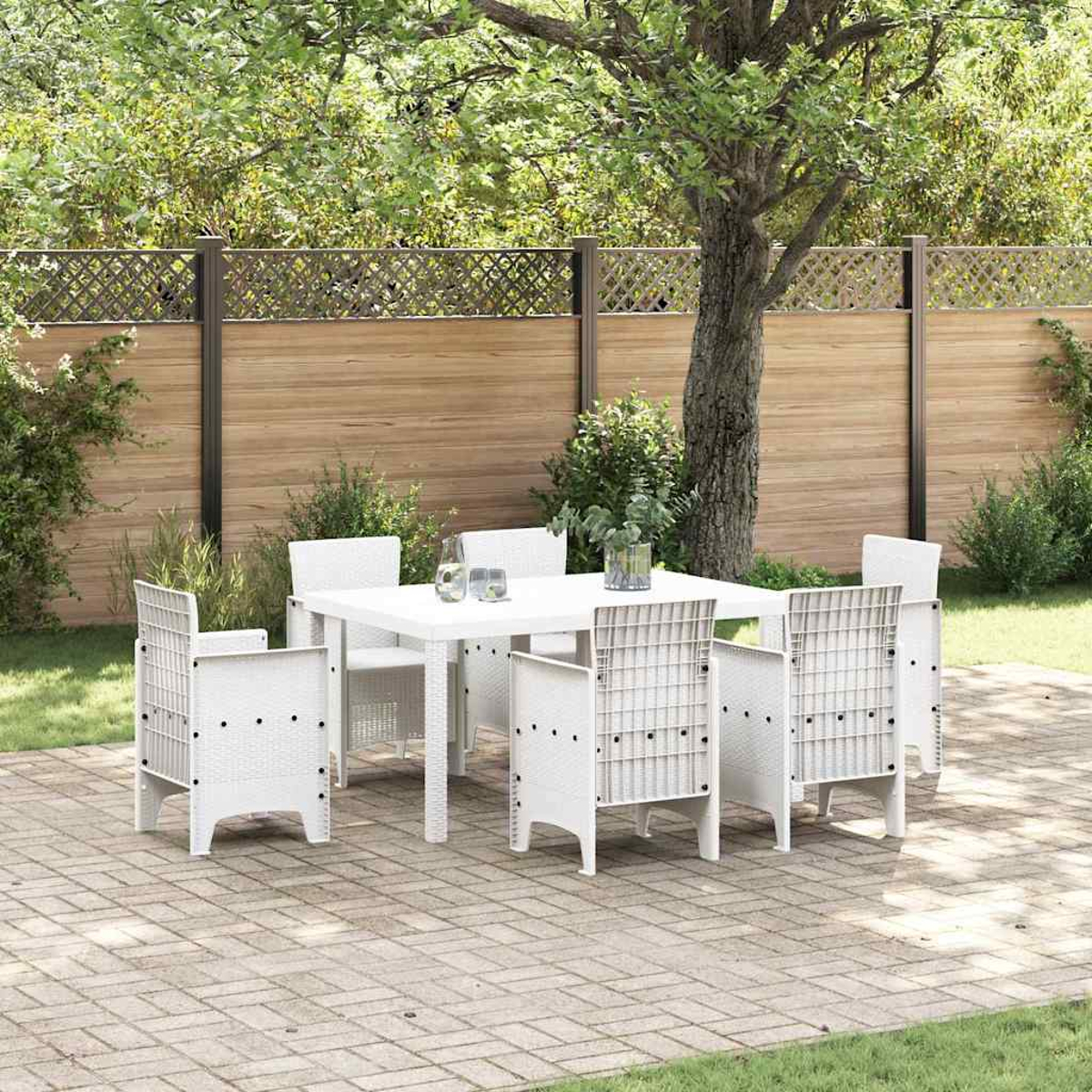 Weißes Terrassenset auf einer Ziegelterrasse. Das Set umfasst einen Tisch und sechs Stühle. Im Hintergrund ein Holzzaun und Bäume.
