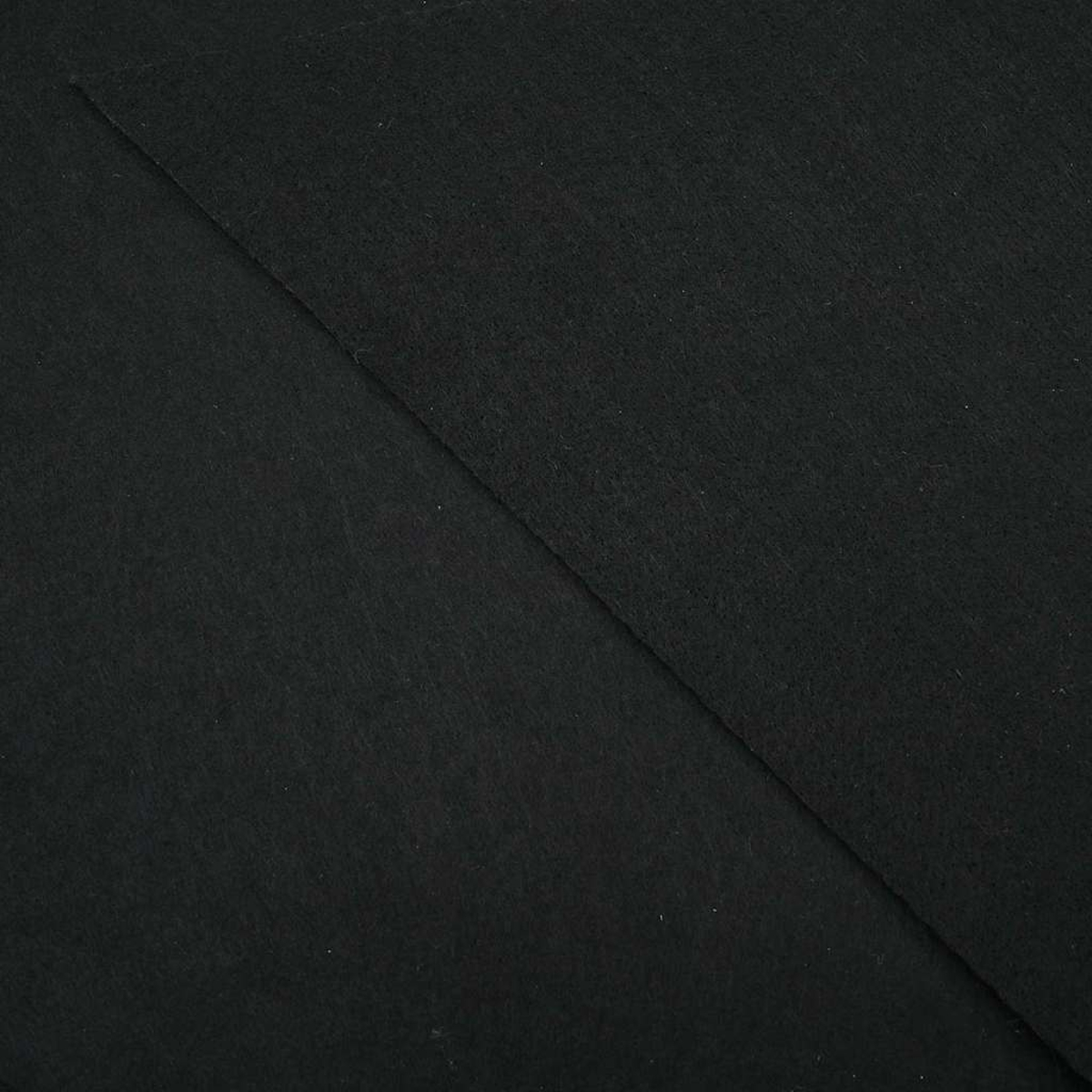 Nahaufnahme eines schwarzen Stoffes. Der Stoff ist diagonal gefaltet und bildet zwei deutlich getrennte Bereiche. Die Textur wirkt weich.