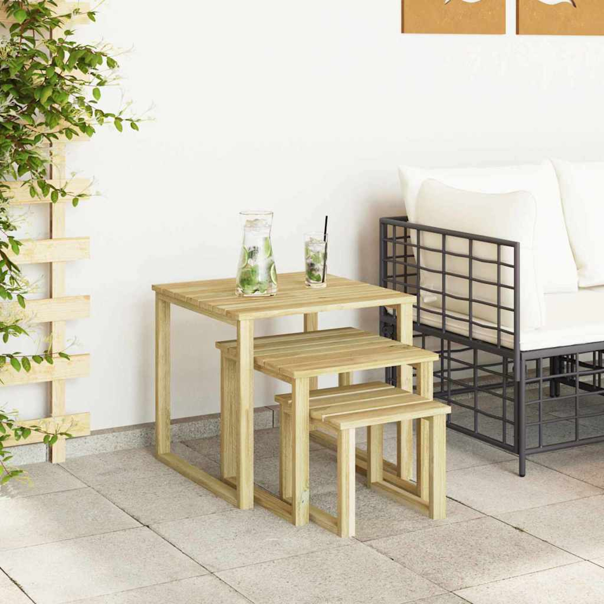 Holztisch-Set mit Getränken, neben einer schwarzen Metallcouch. Eine Kletterpflanze und eine weiße Wand sind sichtbar.
