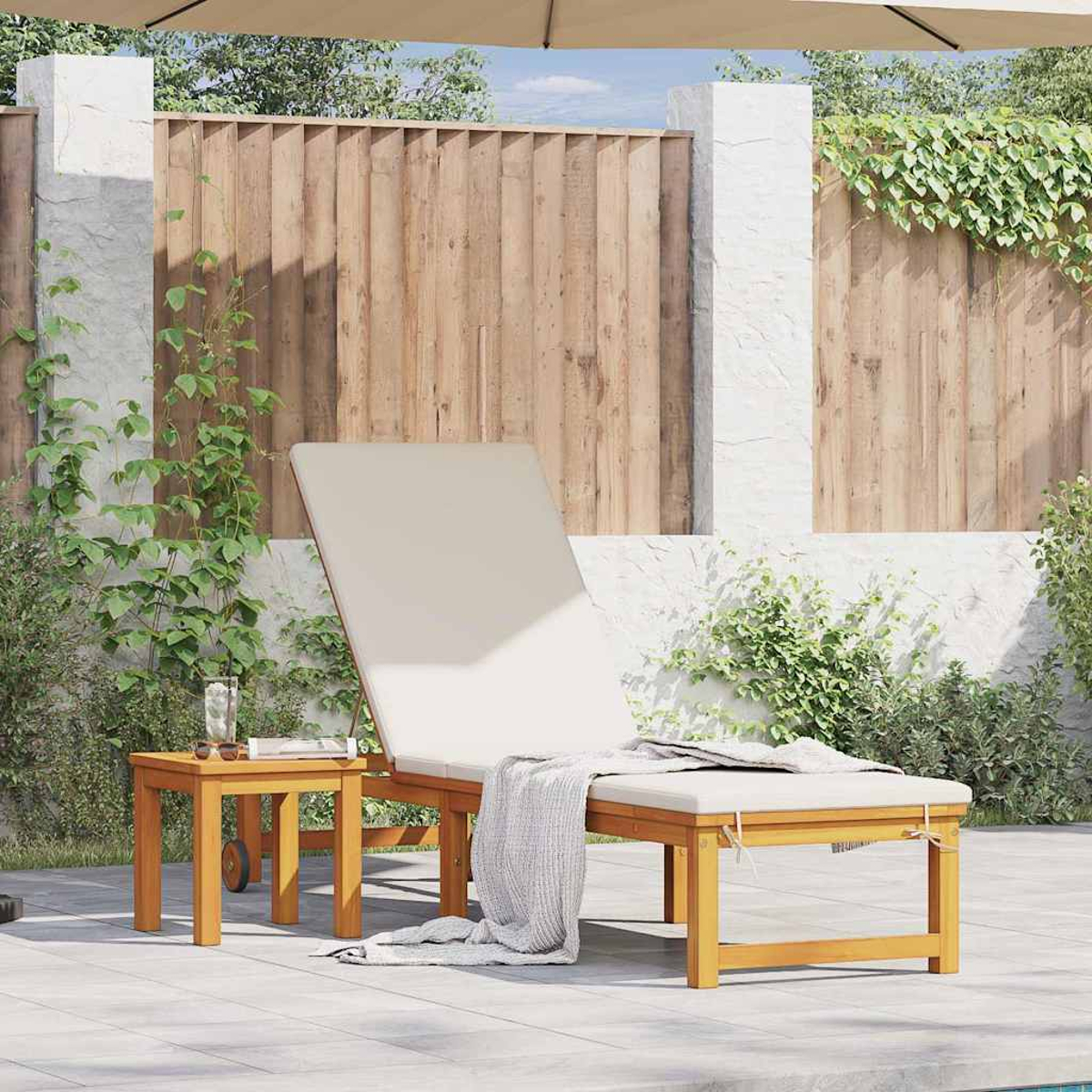 Eine Holzliege mit Beistelltisch steht auf einer Terrasse. Eine Decke liegt auf der Liege, neben einem Glas Wasser und Sonnenbrille.