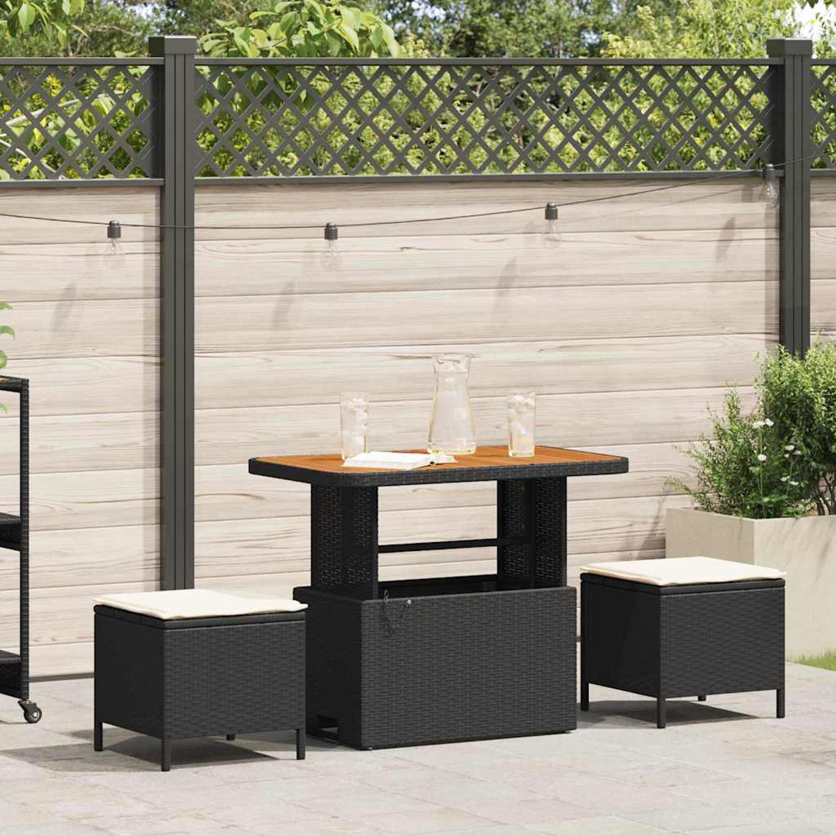 Terrassenset mit Tisch, zwei Hockern und einer Aufbewahrungsbox. Im Hintergrund befinden sich ein Zaun und Pflanzen.