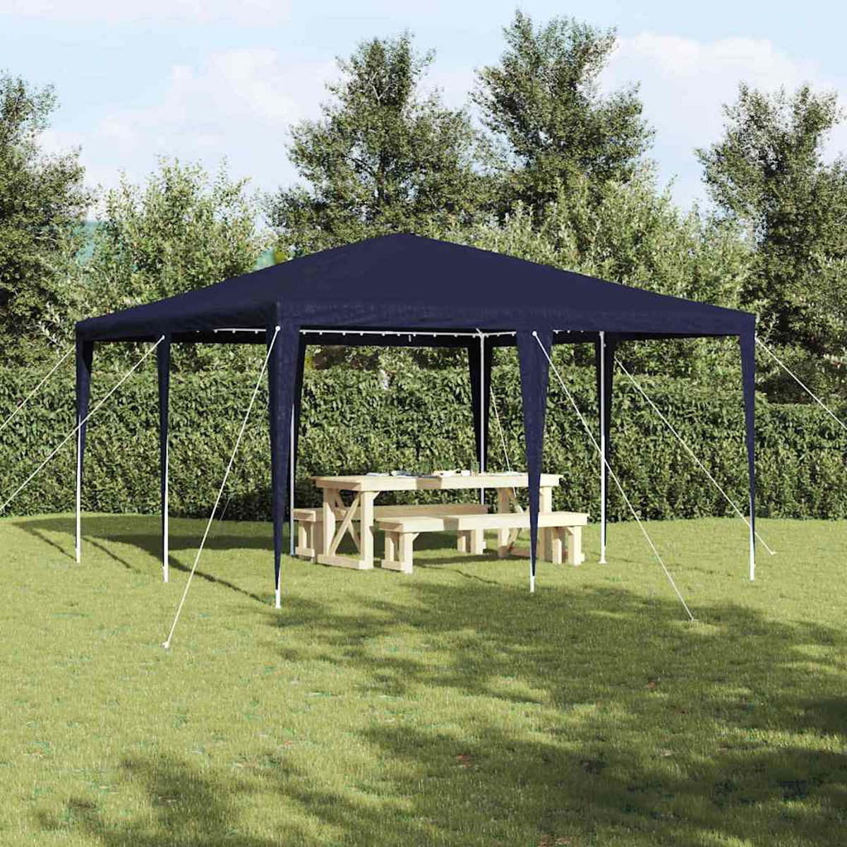 Un gazebo blu navy con un tavolo da picnic si trova su un prato. Gli alberi formano lo sfondo.