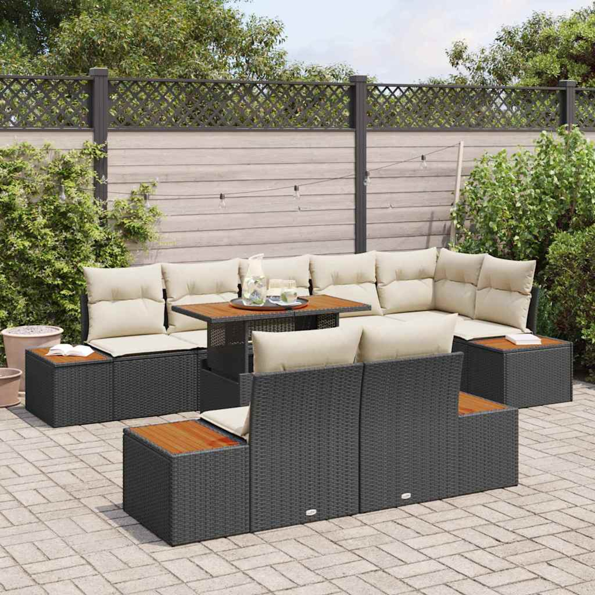 Juego de patio al aire libre con muebles de mimbre gris, cojines beige y una mesa de madera.  En un patio pavimentado con valla y vegetación.