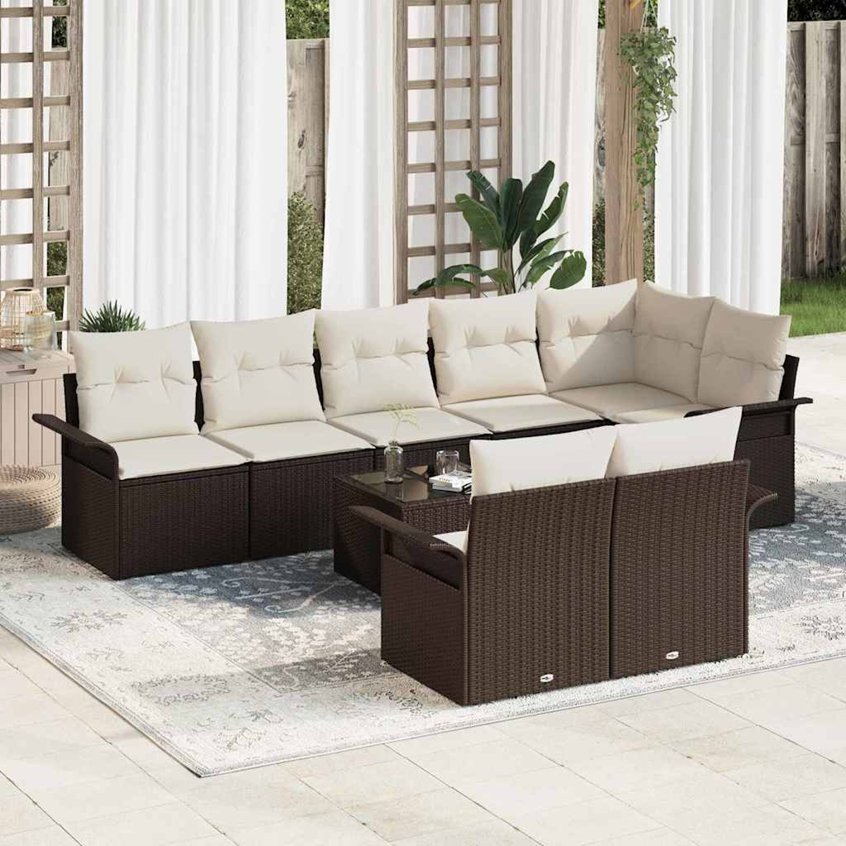 Garten-Sitzgruppe mit braunen Korbflechtrahmen und cremefarbenen Kissen. Enthält ein Ecksofa, ein Loveseat und einen kleinen Tisch auf einem gemusterten Teppich.