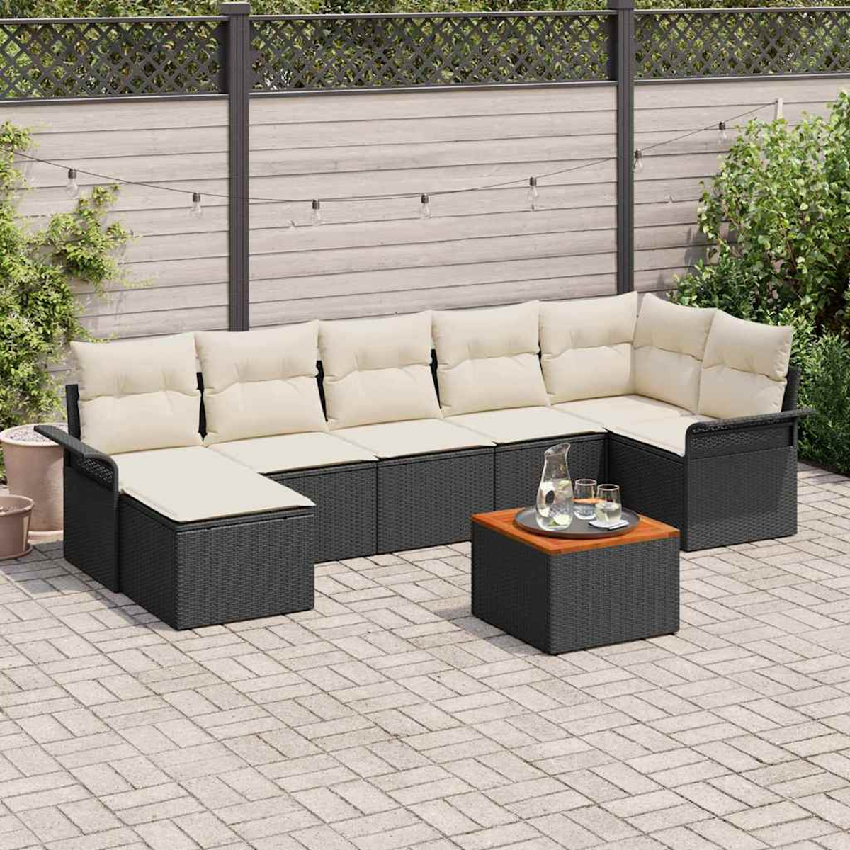 Outdoor-Ecksofa mit cremefarbenen Kissen und schwarzem Rahmen. Davor steht ein kleiner Tisch mit Getränken. Die Szene ist eine Terrasse.