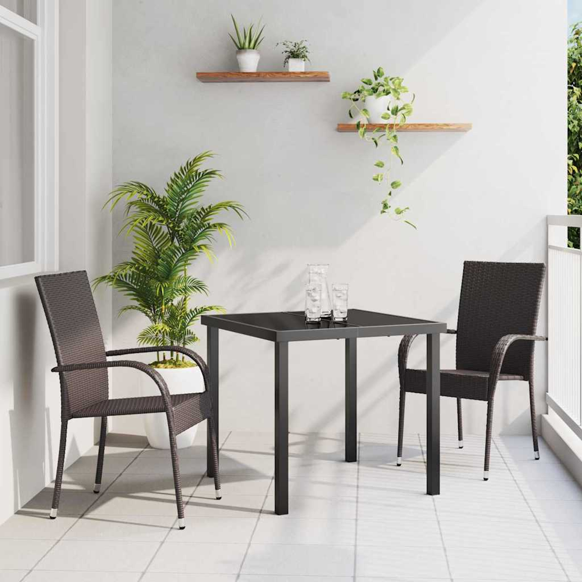 Balkon mit schwarzem quadratischem Tisch, zwei braunen Stühlen, Pflanzen in Töpfen und einer großen Pflanze. Weiße Wände und Boden.
