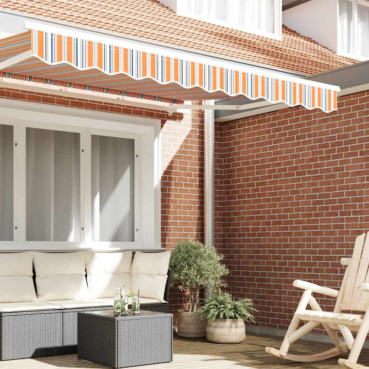 Szene im Freien mit einem gestreiften orange-weißen Markise, Backsteinmauer, weiß gerahmten Fenstern und einem grauen Korbmöbel.