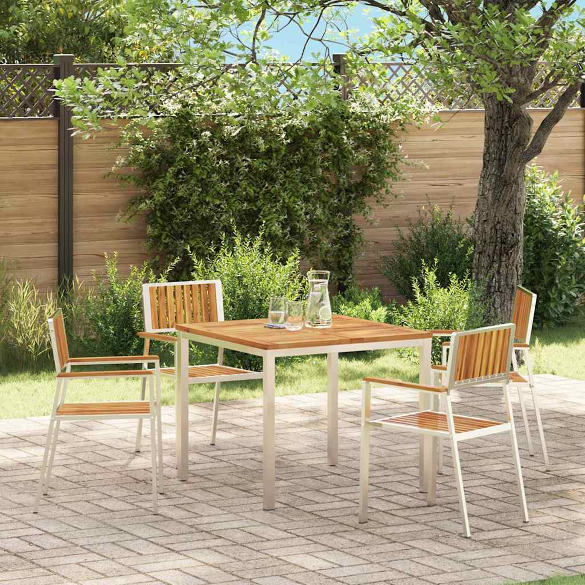 Szene im Freien mit einem quadratischen Tisch und vier Stühlen. Tischplatte und Stühle aus Holz, auf einer Ziegelterrasse. Üppiges Grün umgibt den Bereich.