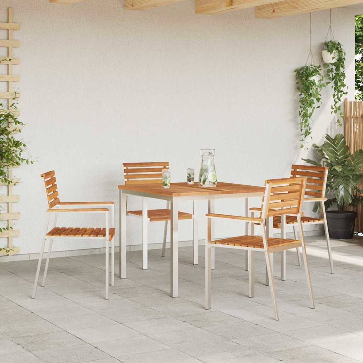 Essgarnitur im Freien: Holztisch und Stühle mit weißen Metallrahmen. Pflanzen und ein Krug auf dem Tisch. Terrasse.