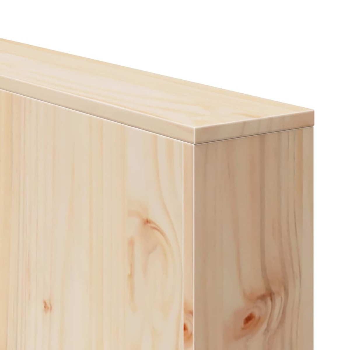 Primer plano de una esquina de caja de madera. La madera es marrón claro con vetas y nudos visibles. El fondo es blanco.