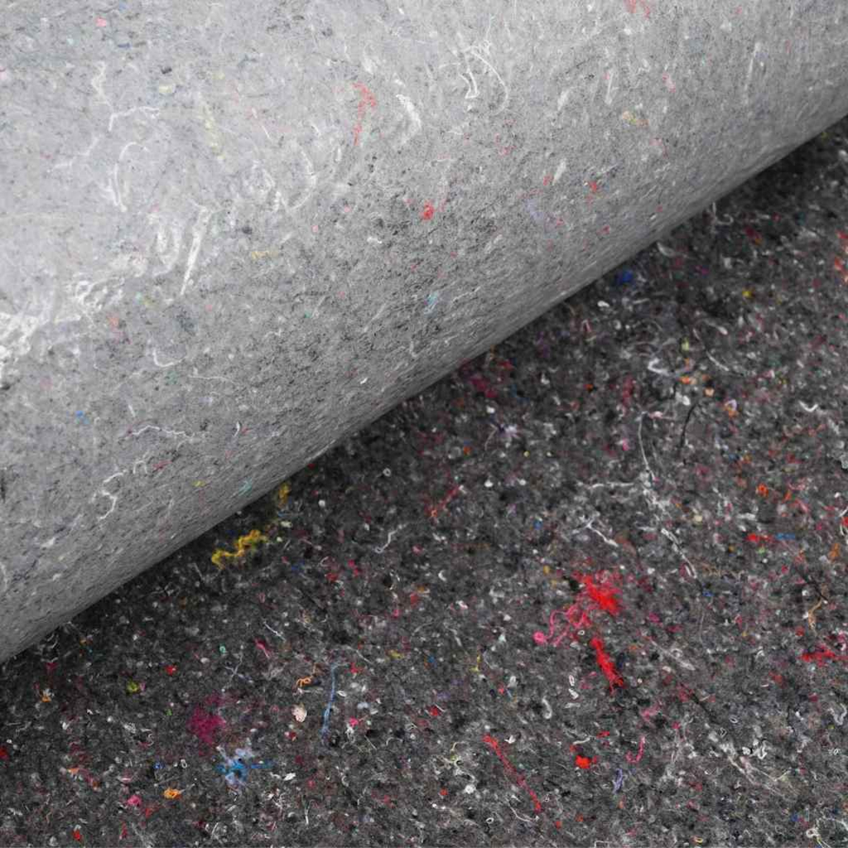 Grauer Filzstoff, aufgerollt, mit mehrfarbiger, gesprenkelter Oberfläche. Der gerollte Abschnitt ist heller als die flache Basis.