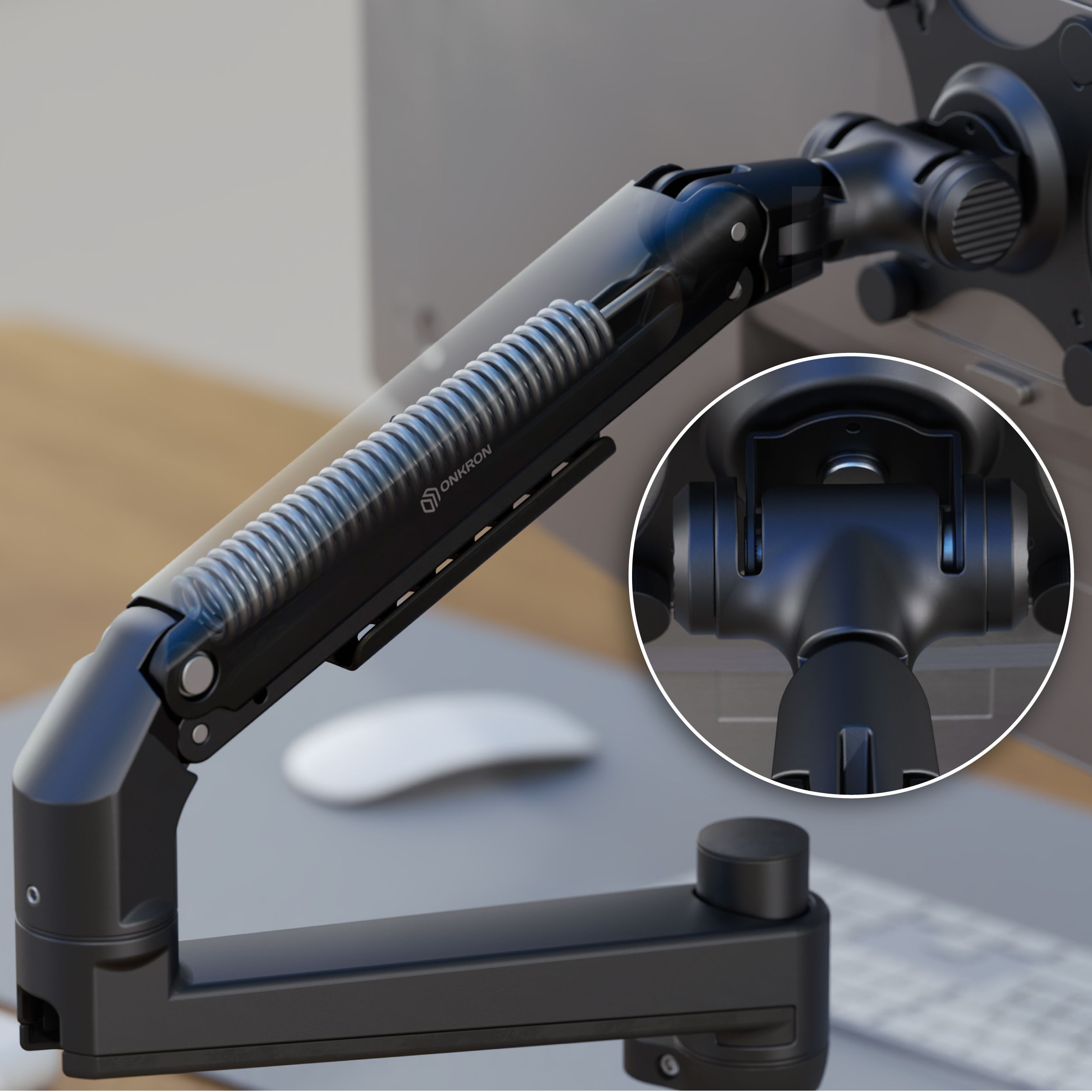 Ein schwarzer Monitorarm mit Feder und der Marke "ONKRON". Im Hintergrund ein Schreibtisch und eine Computermaus.