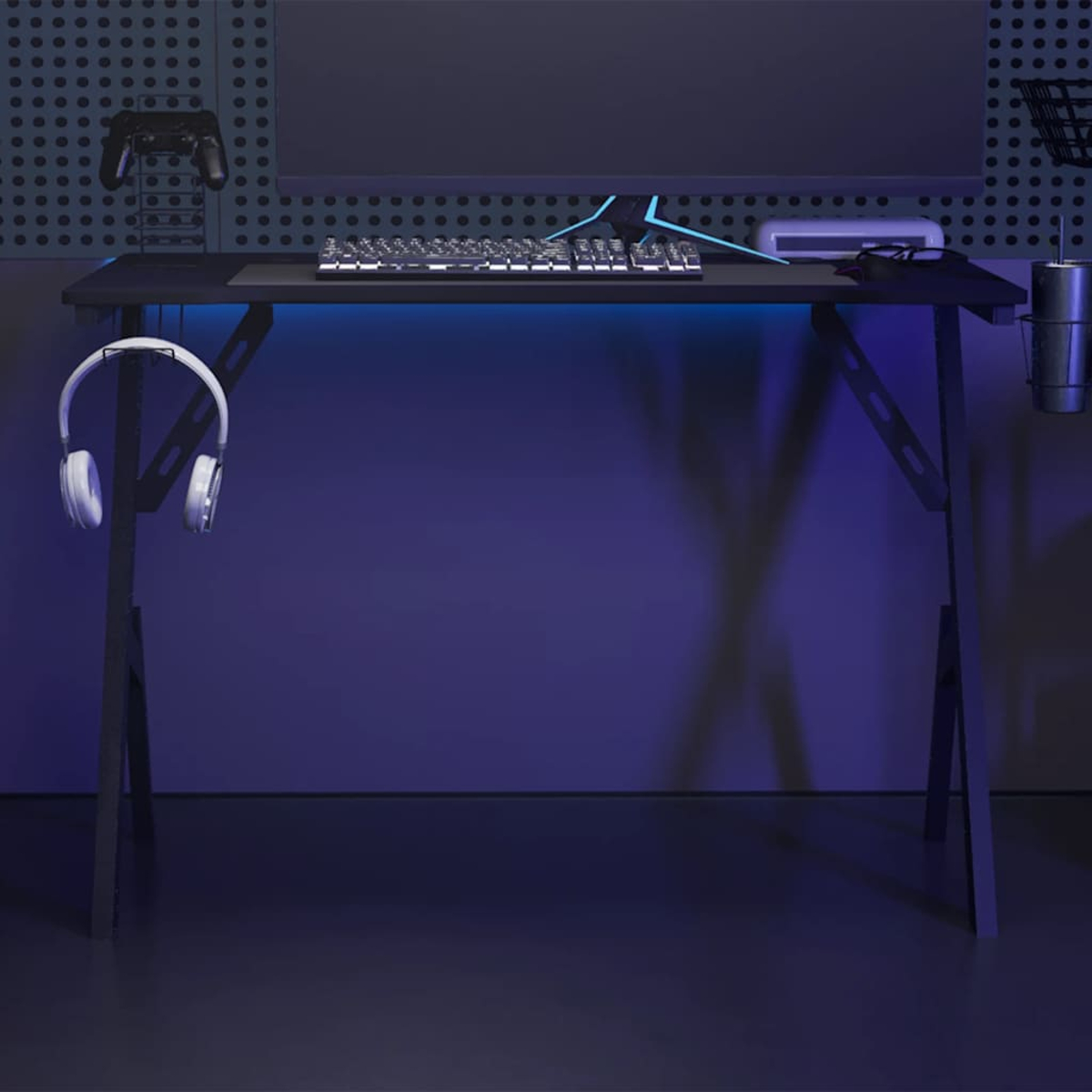 Gaming-Schreibtisch mit Monitor, Tastatur und Zubehör. Kopfhörer hängen links. Blaue Beleuchtung beleuchtet Tisch und Wand.