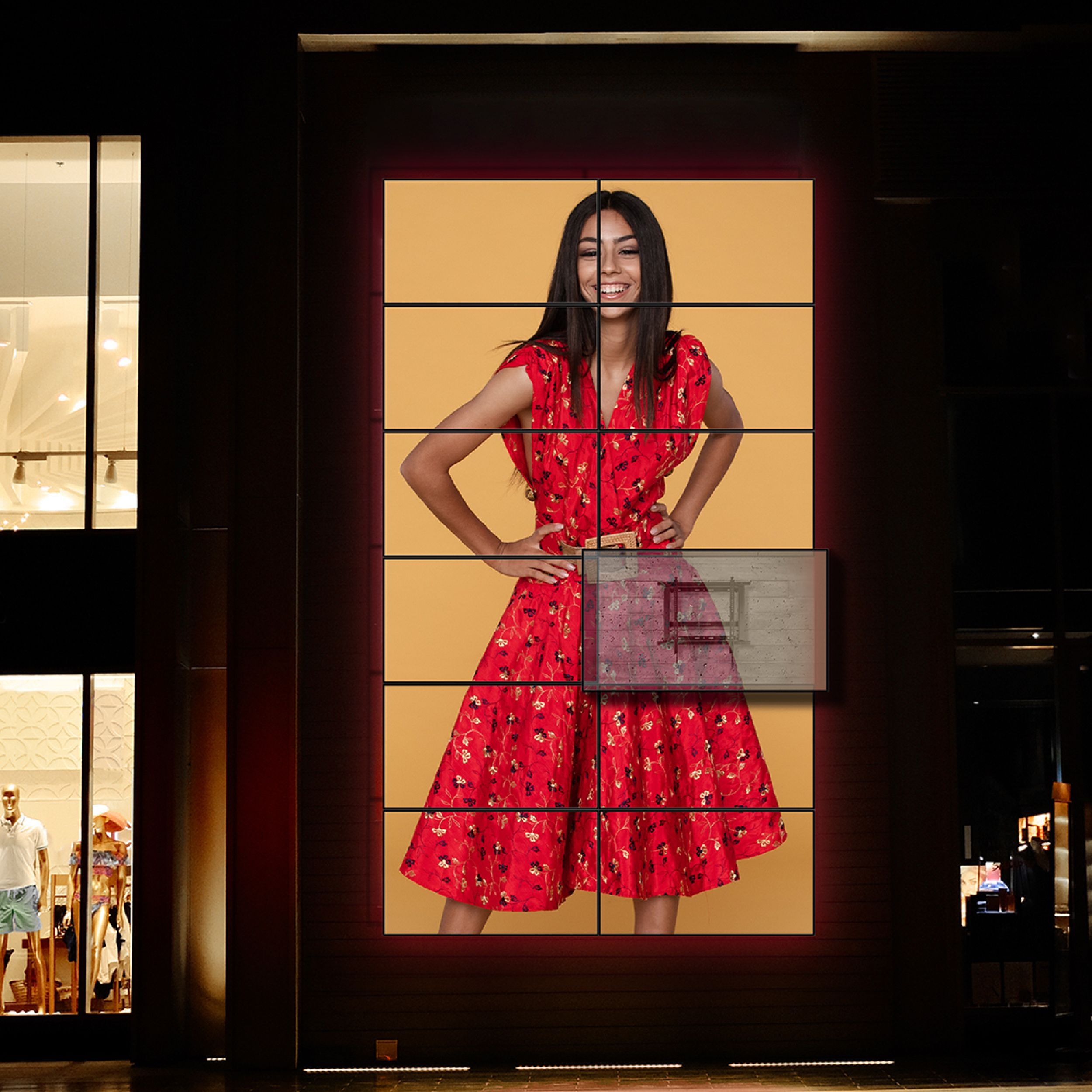 Frau in rotem Kleid mit Händen auf den Hüften, lächelnd. Hintergrund ist gelb. Schaufenster sind an den Seiten.