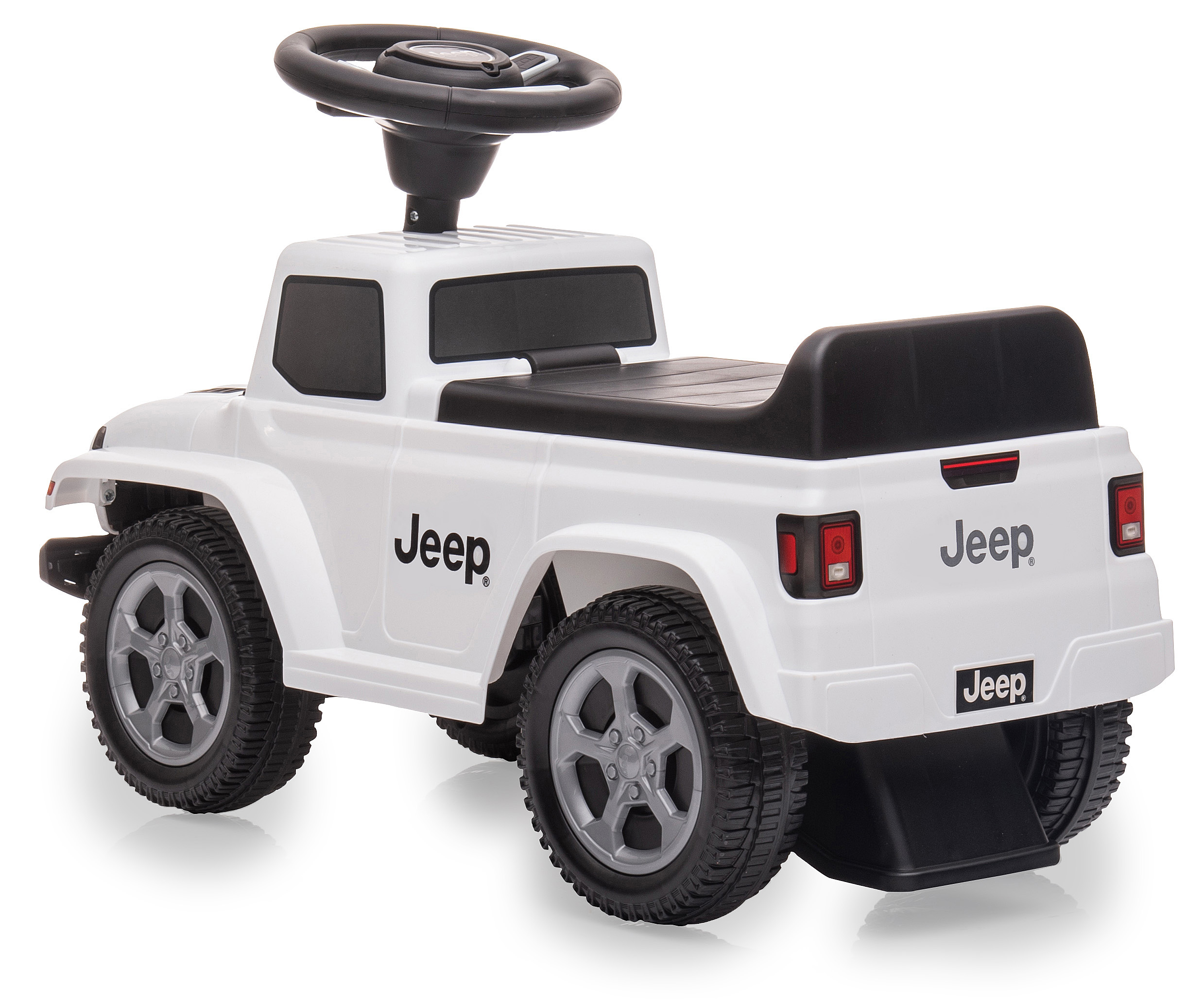 Ein weißes Jeep-Spielzeug. Es hat schwarze Räder, ein Lenkrad und das Jeep-Logo. Es steht auf einer weißen Oberfläche.