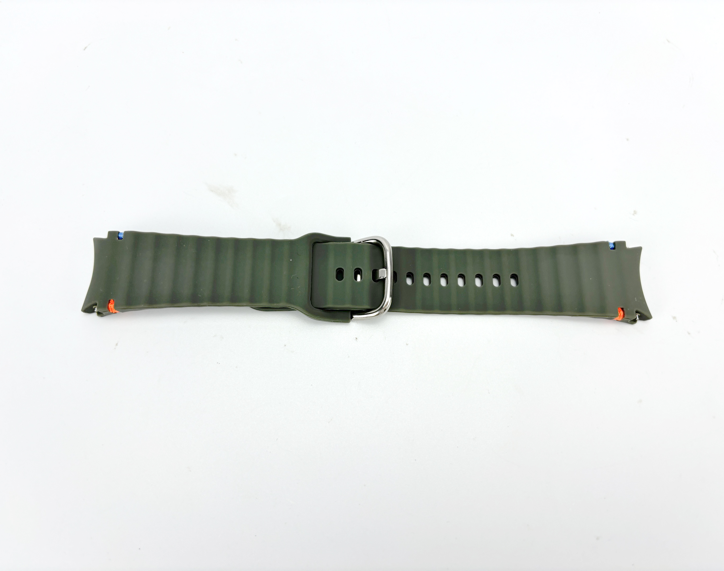 Ein olivgrünes Uhrenarmband liegt auf weißem Hintergrund. Es hat eine silberne Schnalle und mehrere Verstelllöcher.
