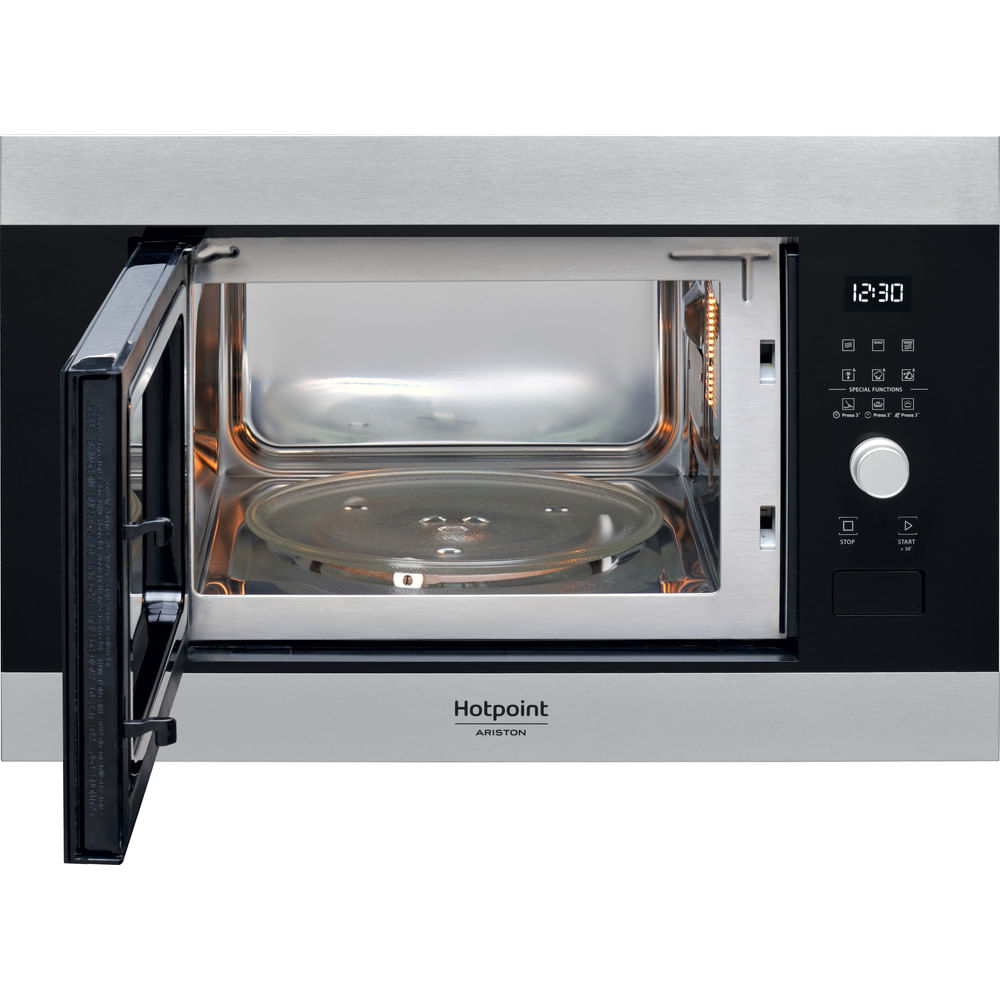 Un horno microondas plateado está abierto, revelando un plato de vidrio en el interior. La puerta está abierta a la izquierda. La pantalla digital muestra la hora.