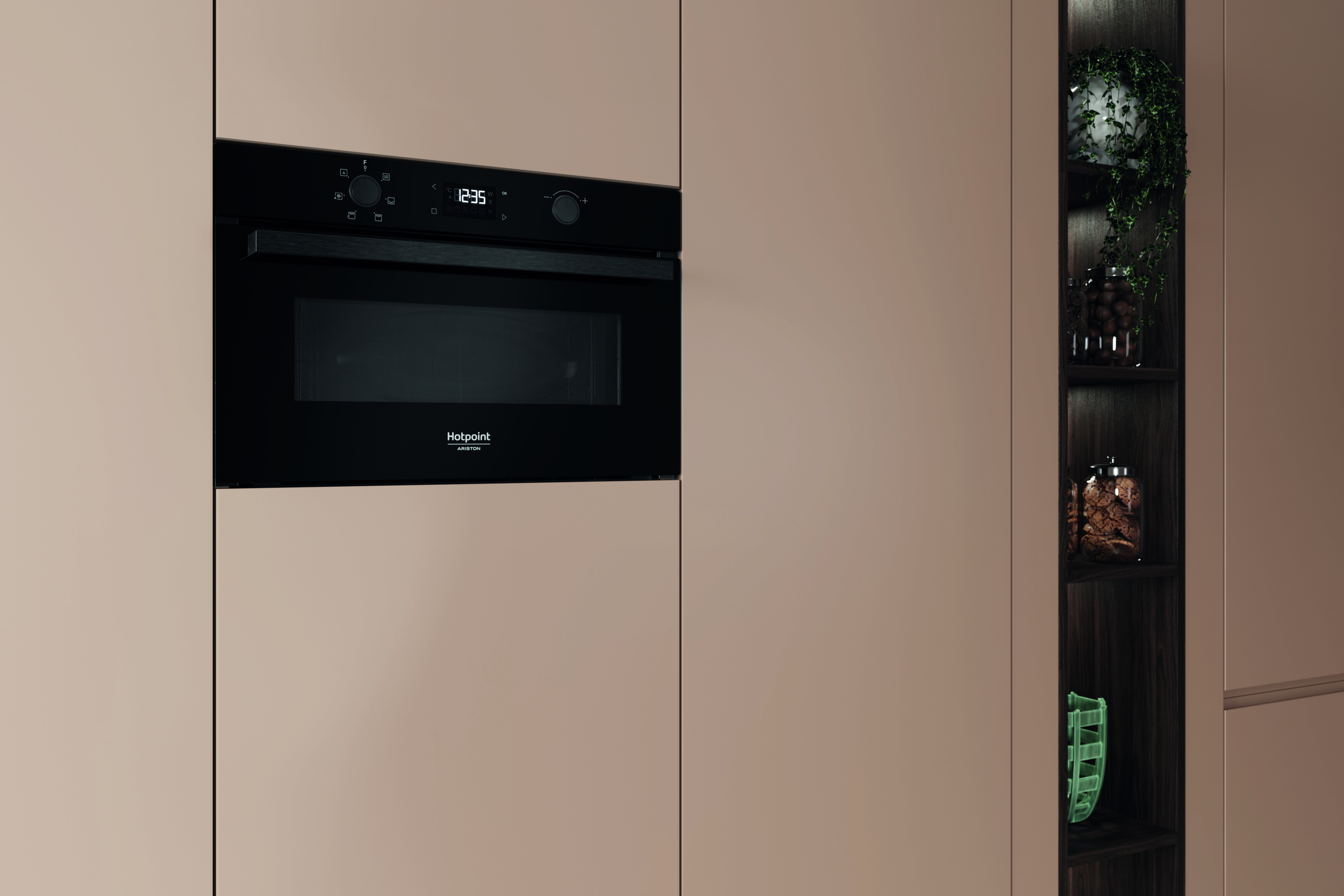 Un forno a microonde nero a incasso con orologio digitale mostra le 12:35. Accanto, un mobile scuro in legno con mensole e piante.