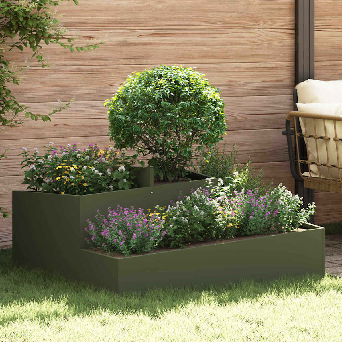 Ein gestuftes Gartenbeet mit Pflanzen und Blumen steht vor einem Holzzaun. Ein Baum und ein Stuhl sind im Hintergrund.
