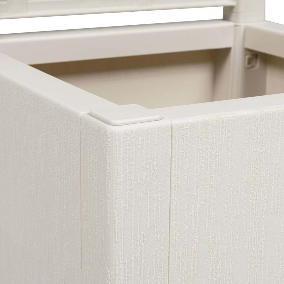 Primo piano di un contenitore di plastica color crema. La superficie strutturata mostra l'angolo e parte del coperchio, in un ambiente neutro e ben illuminato.