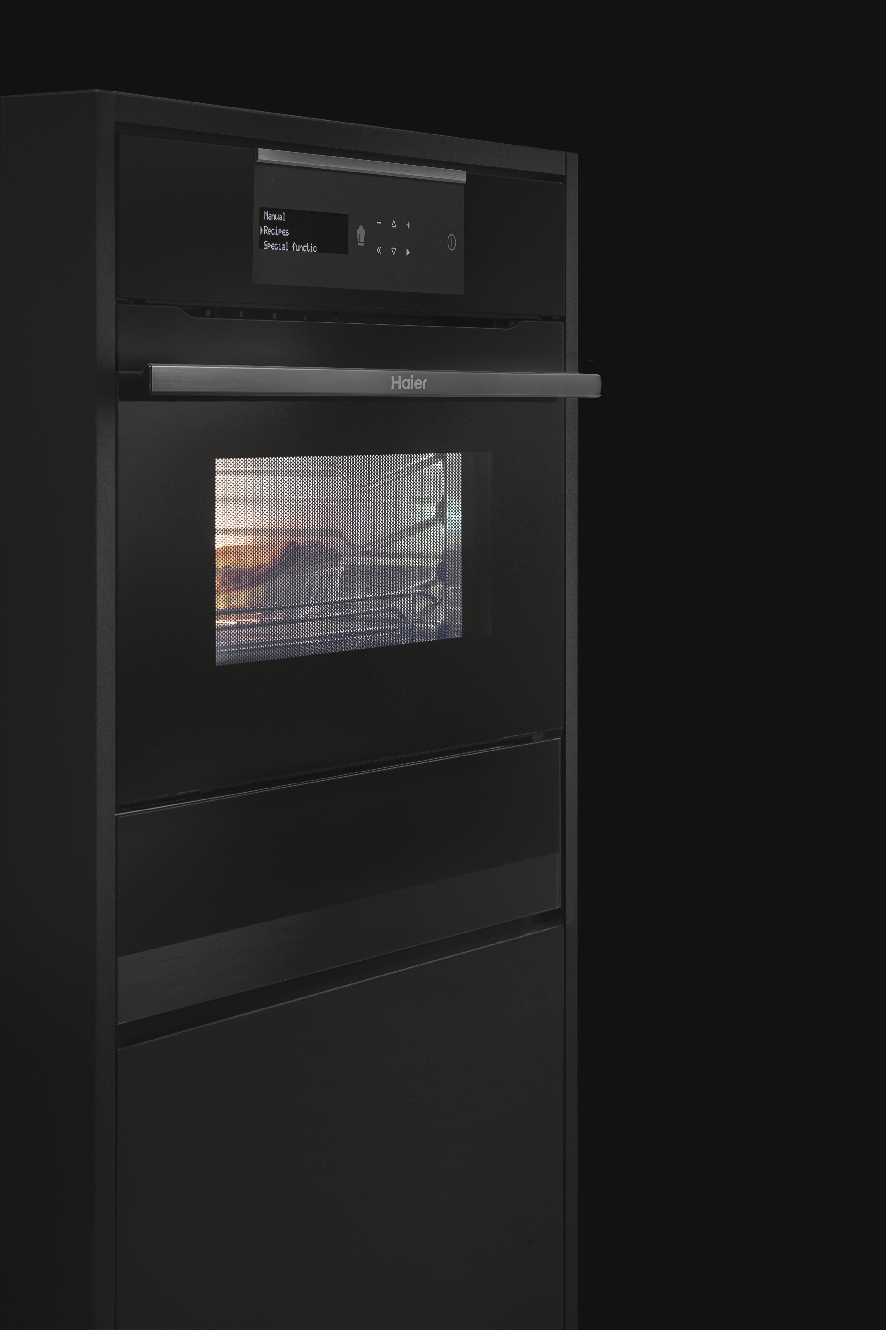 Horno negro empotrado con asa y pantalla, con opciones como manual y recetas. La puerta del horno es transparente.