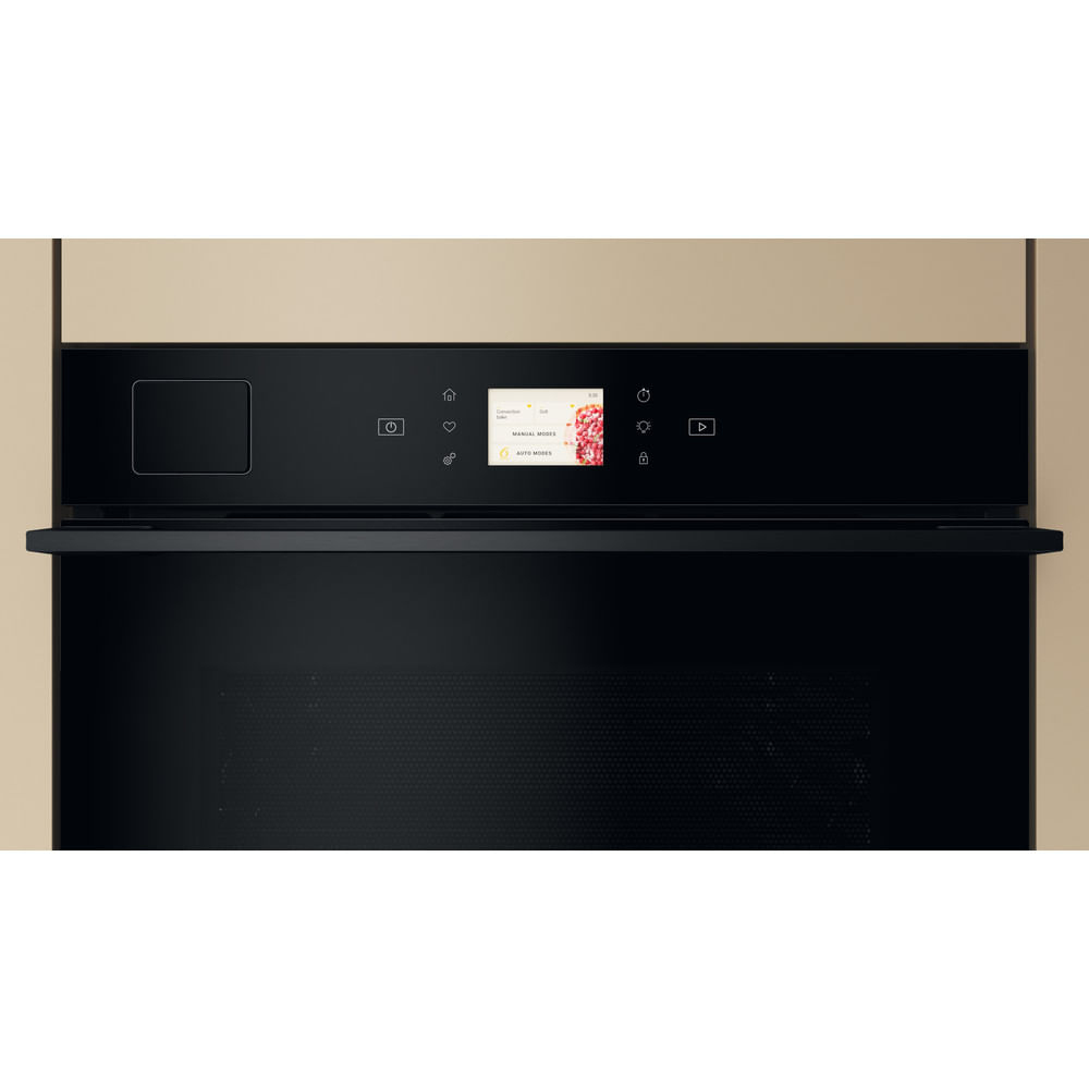 Un forno nero con display touch. Il display mostra le opzioni del menu. La porta del forno è chiusa. Muro beige sullo sfondo.