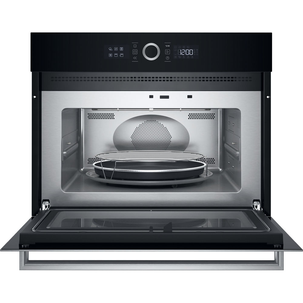 Forno a microonde nero da incasso con porta aperta. L'interno ha un vassoio di metallo, una griglia e una porta di vetro. Orologio digitale in alto.
