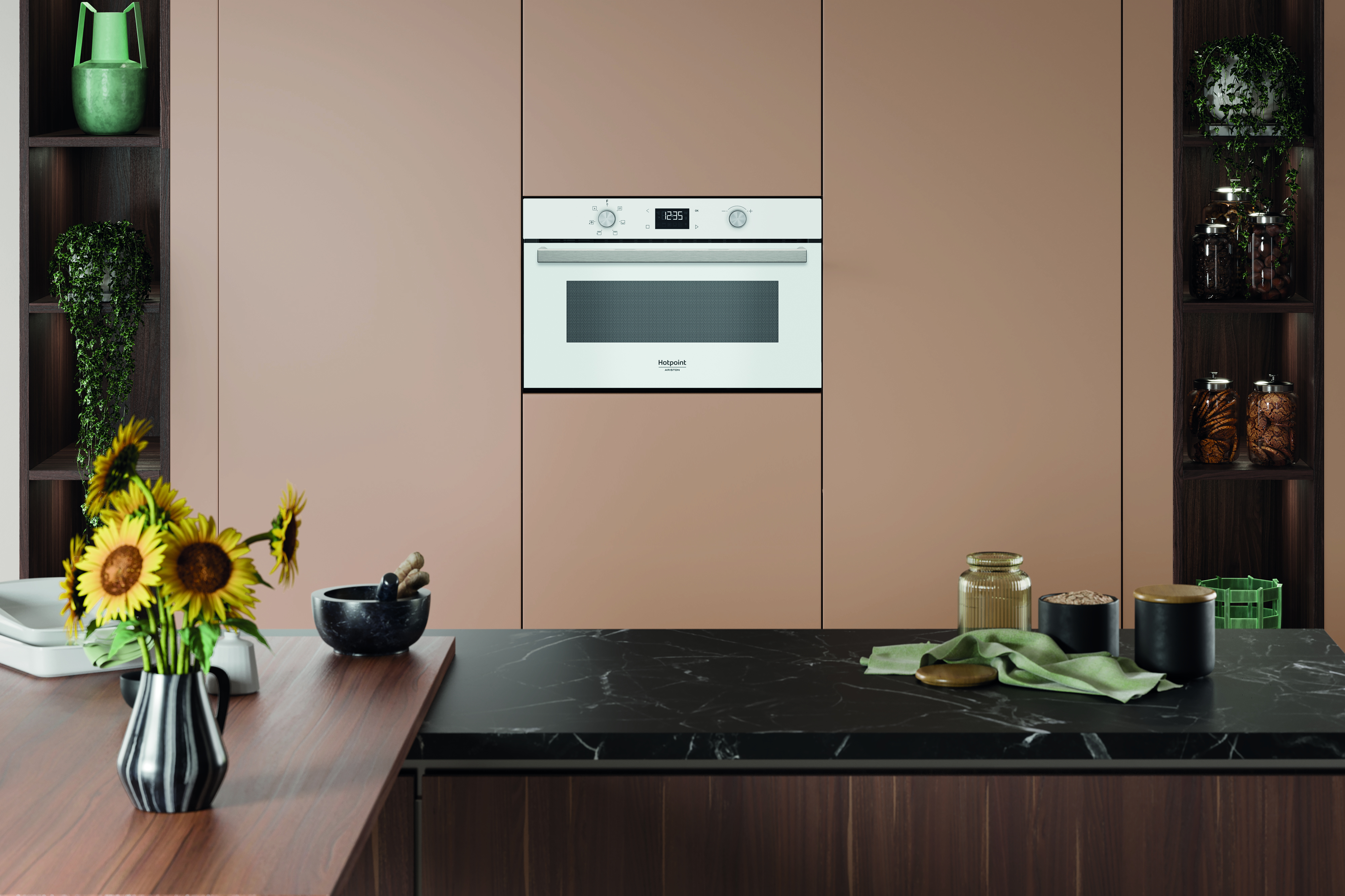 Scena cucina con forno, mensole con piante e barattoli, girasoli in un vaso e piano di lavoro nero.