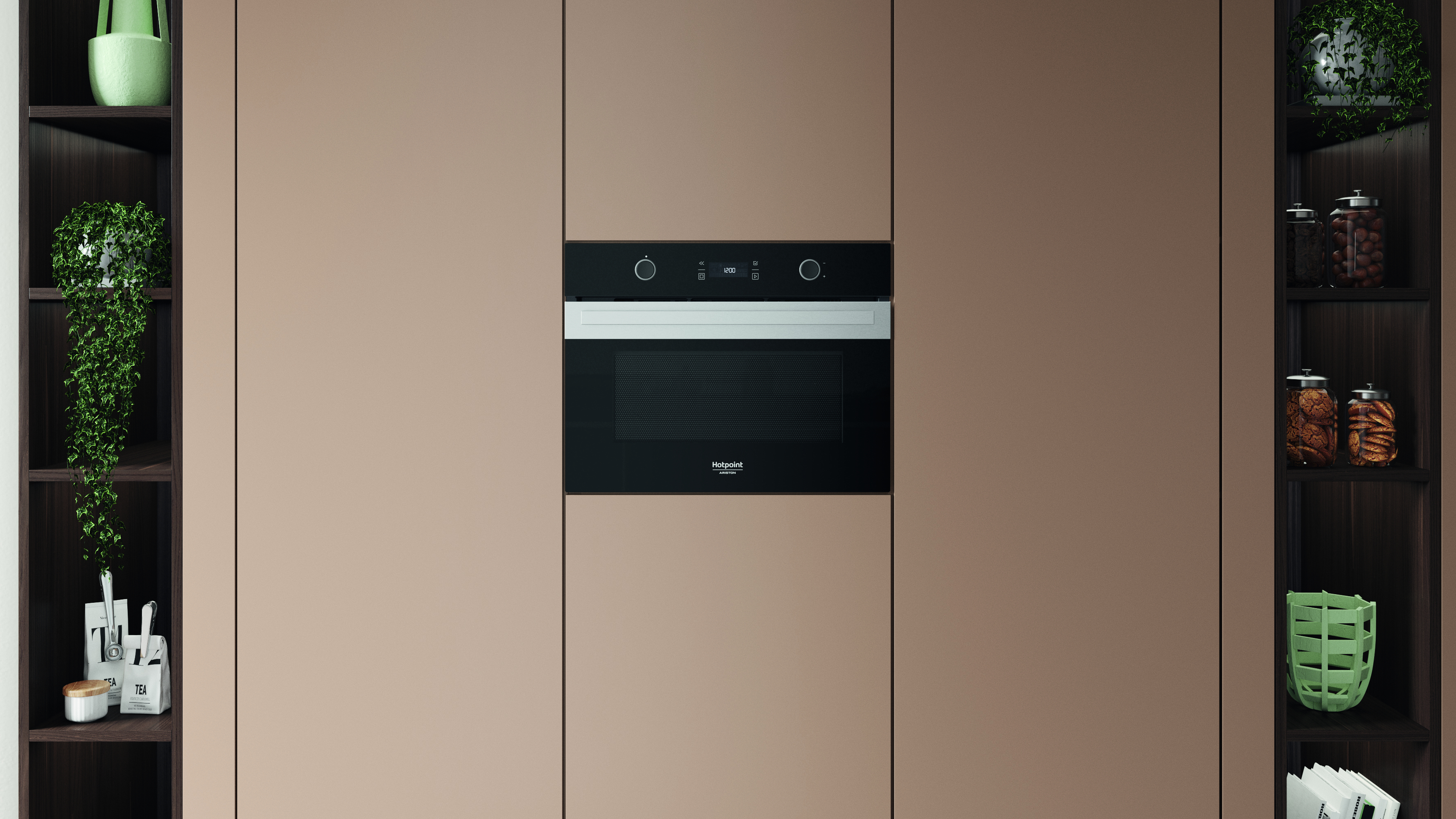 Una scena di cucina con un forno a microonde nero incorporato al centro. Gli armadi lo fiancheggiano con piante sugli scaffali. Porte beige.