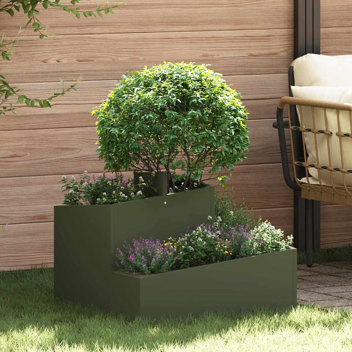 Una fioriera verde a più livelli con fiori e un'arte topiaria. Lo sfondo include una recinzione in legno e una sedia con cuscini.