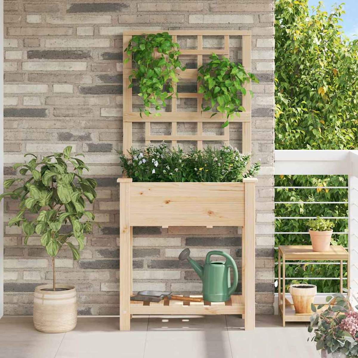 Fioriera in legno con piante, annaffiatoio verde e tavolino. Sfondo di muro di mattoni con pianta rampicante e verde.