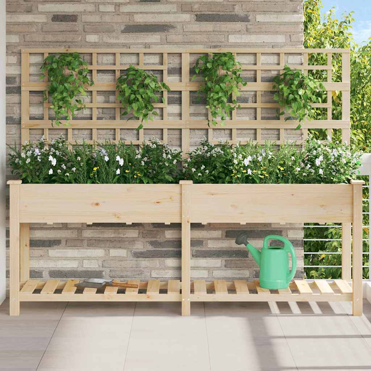 Fioriera in legno con fiori e piante pensili contro un muro di mattoni. Un annaffiatoio verde è sullo scaffale.
