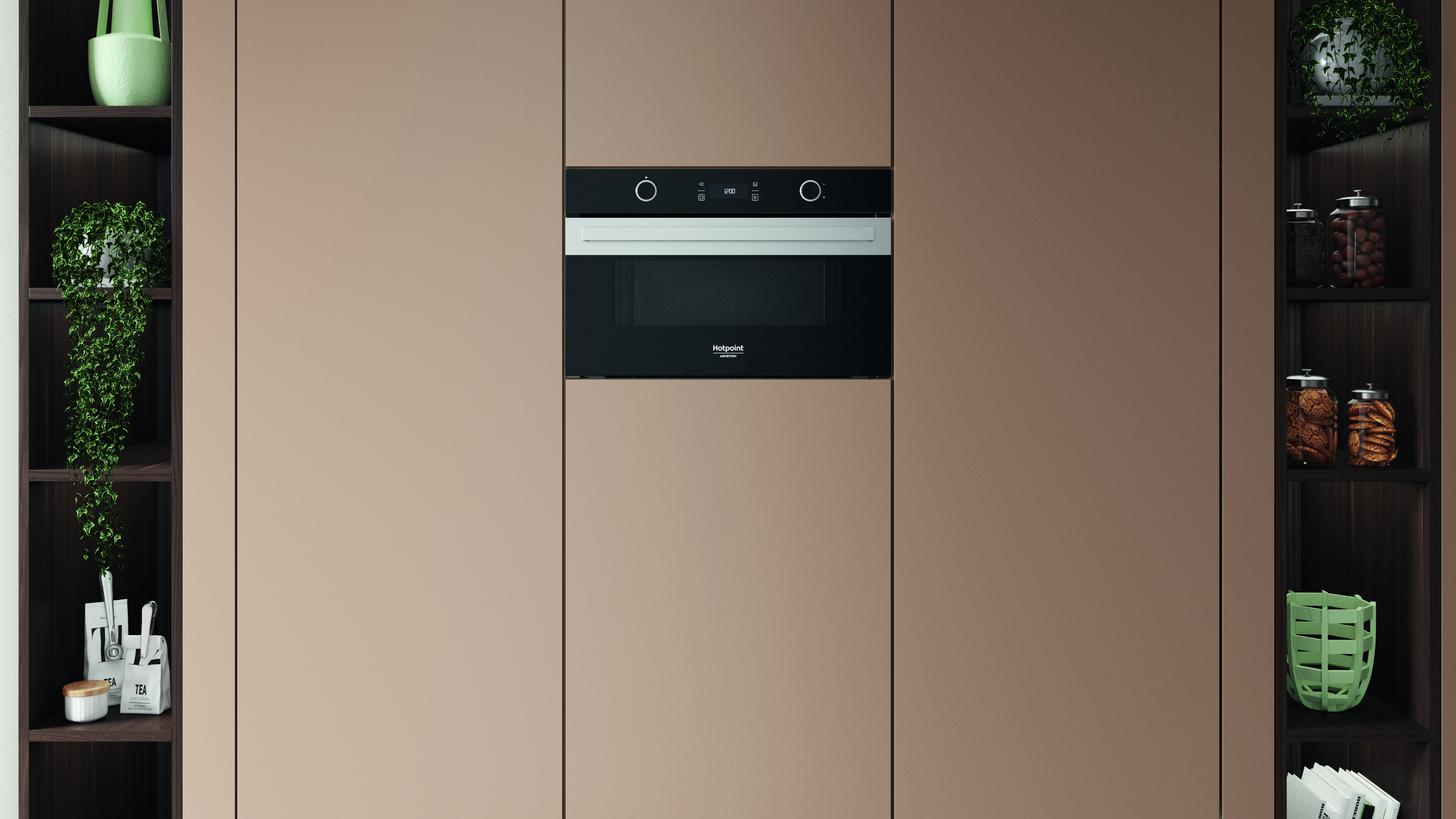Una parete della cucina con forno a microonde integrato, affiancata da mensole scure con piante e barattoli. Armadi beige circondano il forno.