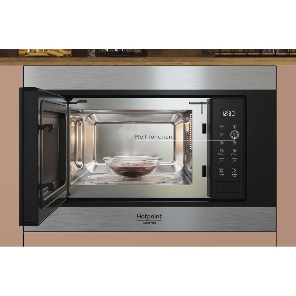 Een open magnetron met een glazen kom erin. Het woord "Melt function" wordt weergegeven. De klok geeft 12:30 aan. Het Hotpoint-logo is zichtbaar.
