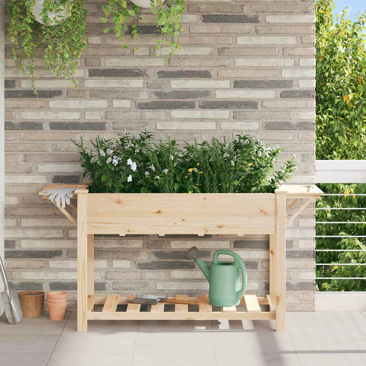 Fioriera in legno con piante su un balcone. Muro di mattoni grigi sullo sfondo. Annaffiatoio e attrezzi da giardinaggio sullo scaffale.